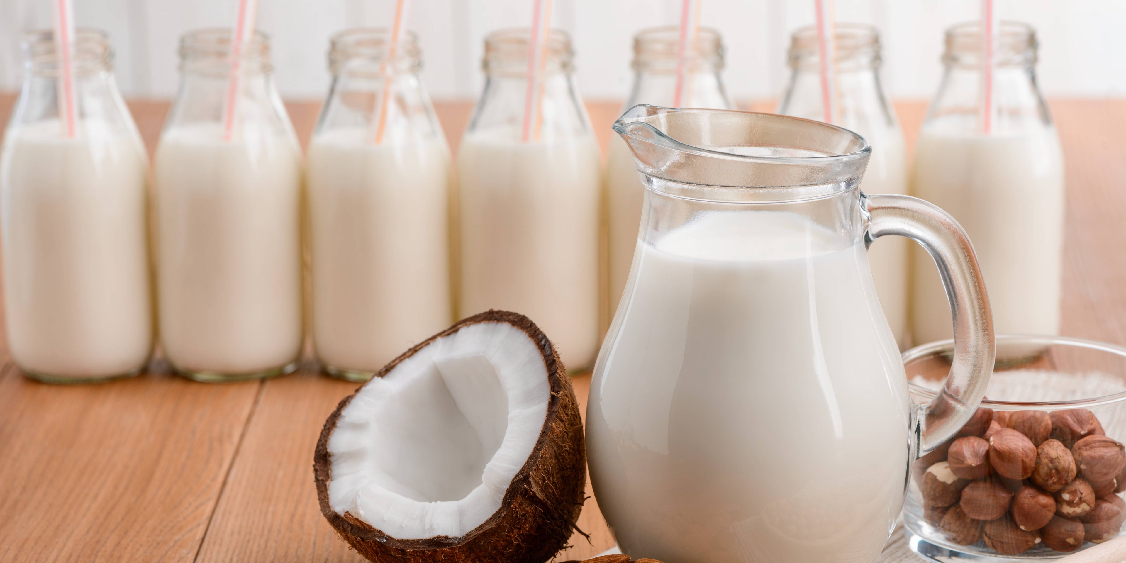 Jug of milk alongside dairy-free milk alternatives, including nuts and coconuts