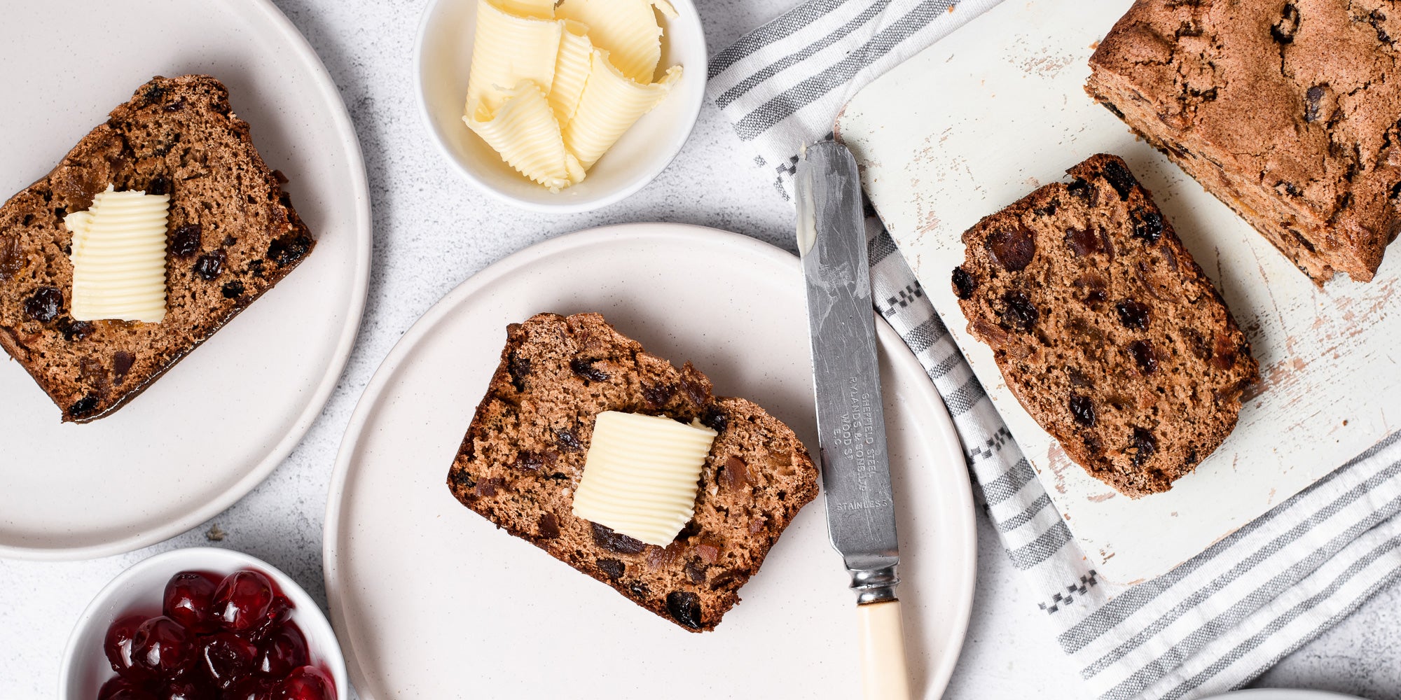 Irish Tea Brack sliced on plates with butter and preserves