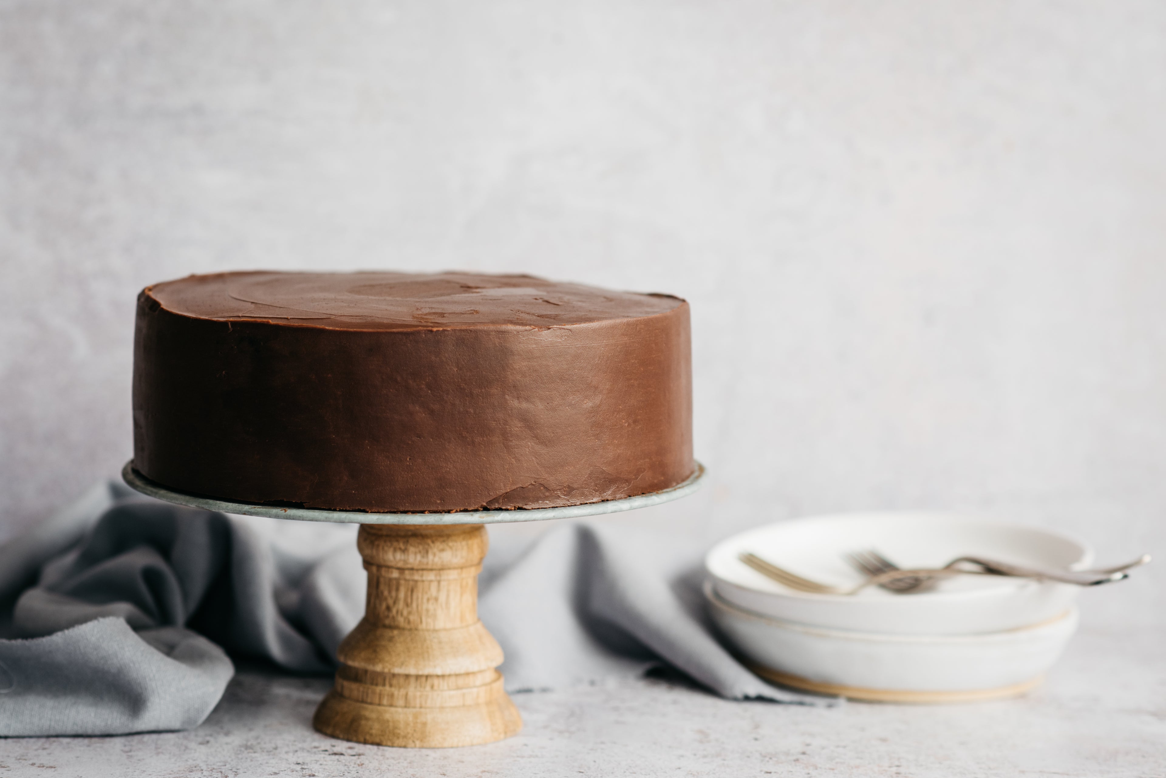 Best Chocolate Cake smothered in chocolate ganache on a cake stand 