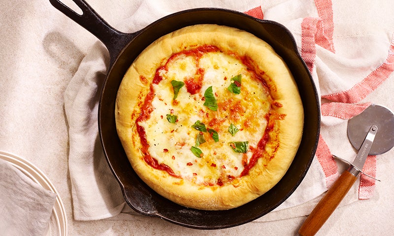 Deep Pan Pizza with tomato and mozzarella sitting in an iron skillet