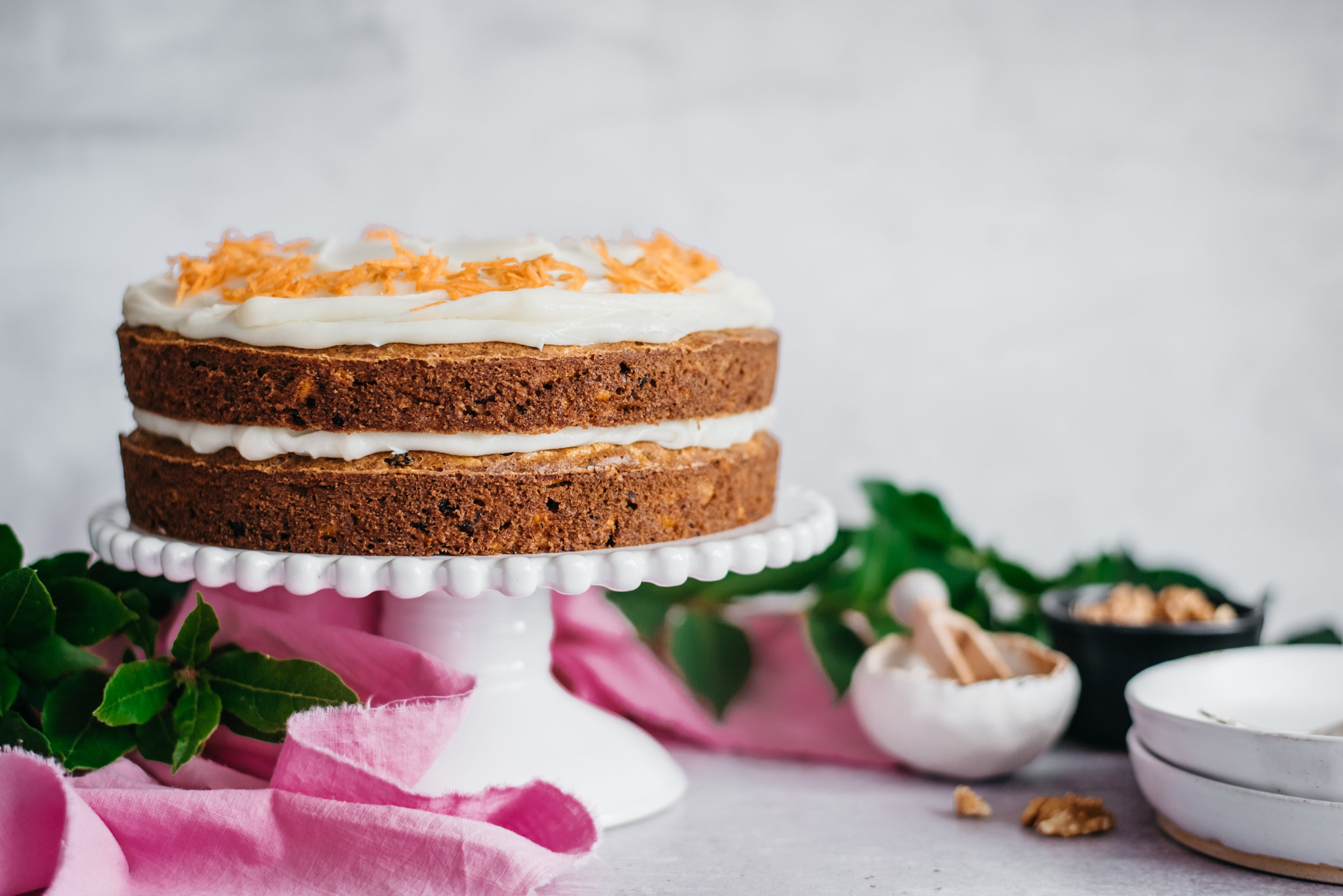 Side on view of a low sugar carrot cake on a cake on a cake stand