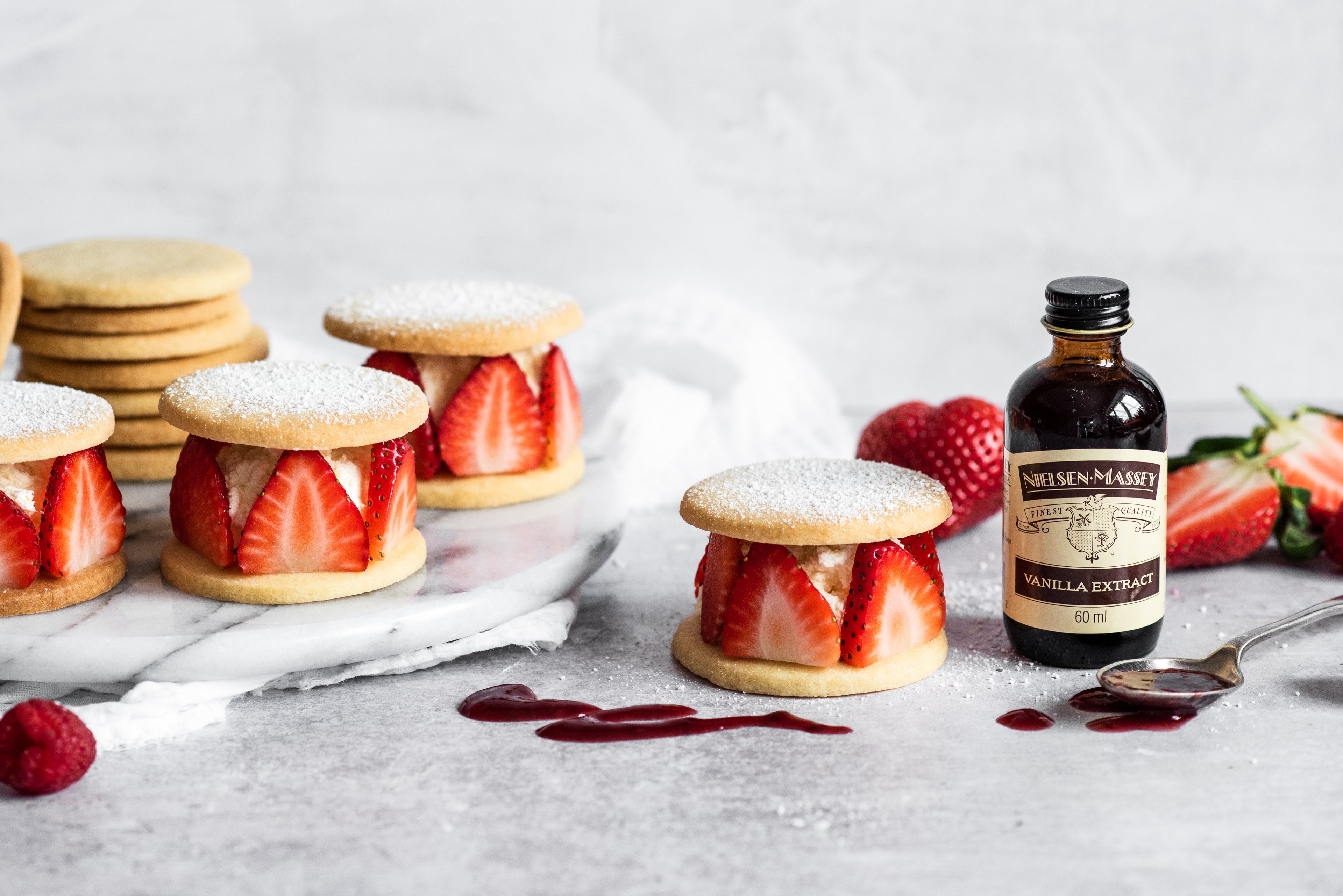 Shortbread rounds with sliced strawberries and cream sandwiched between