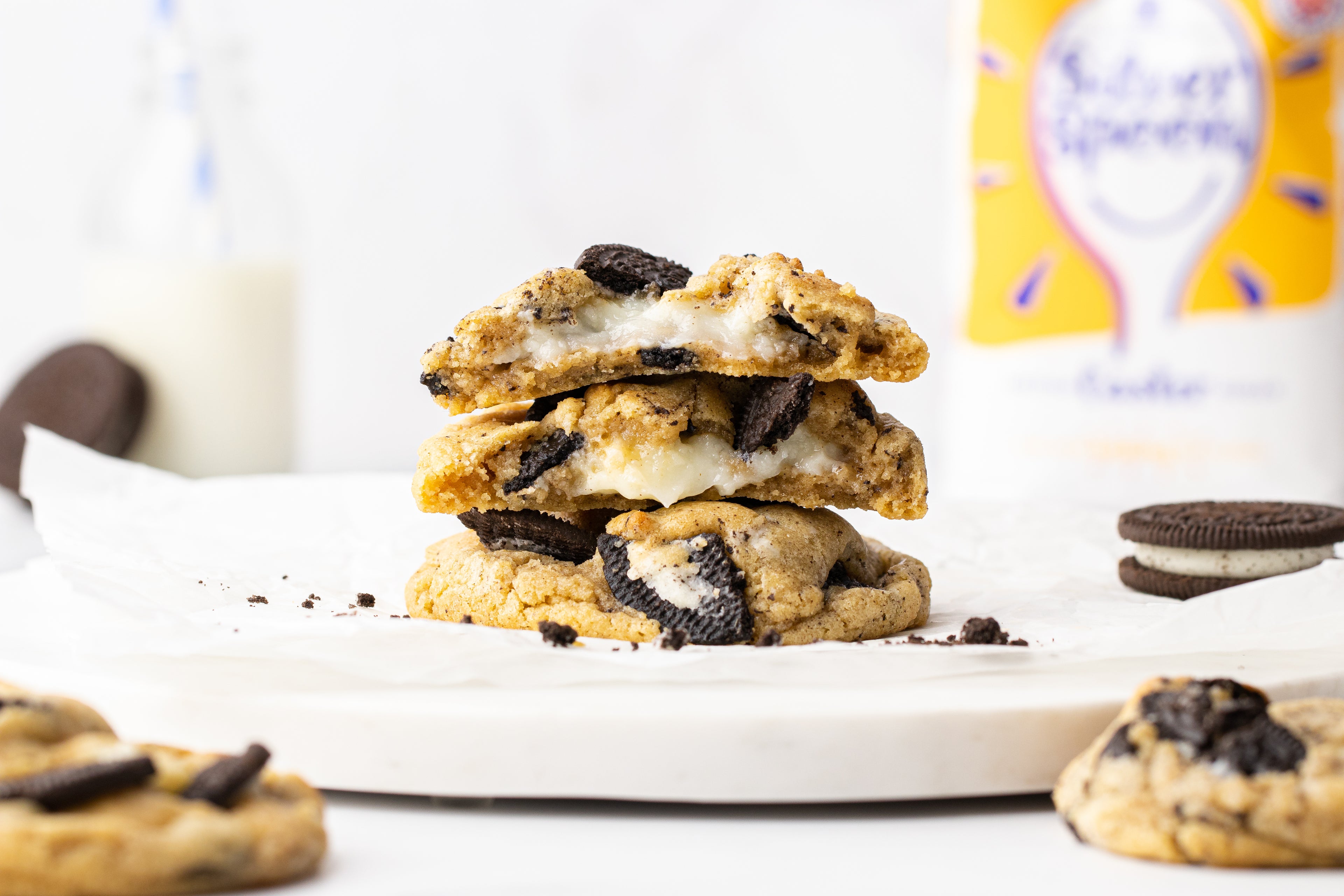 Stack of cookies on a white plate with oozy white filling