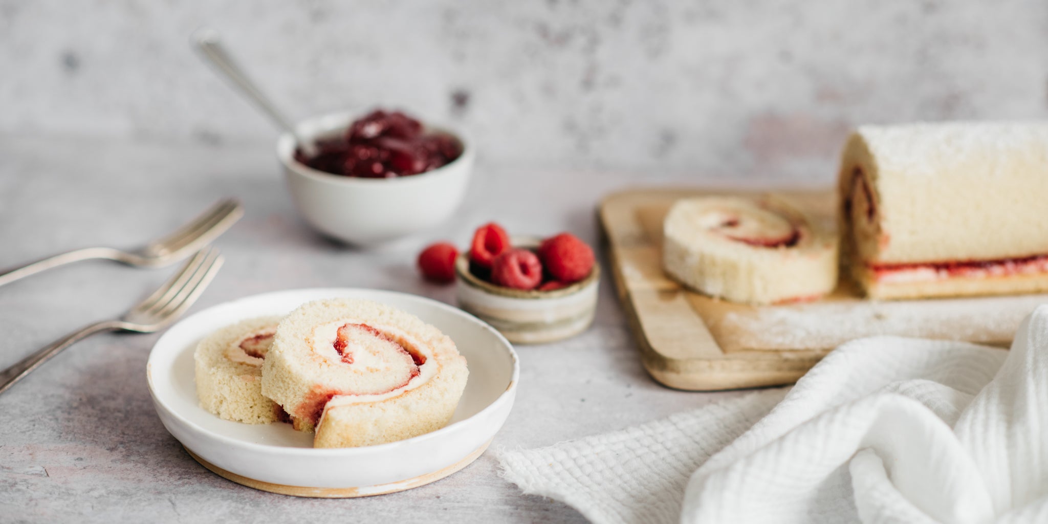 Two slices of vanilla swiss roll on a plate