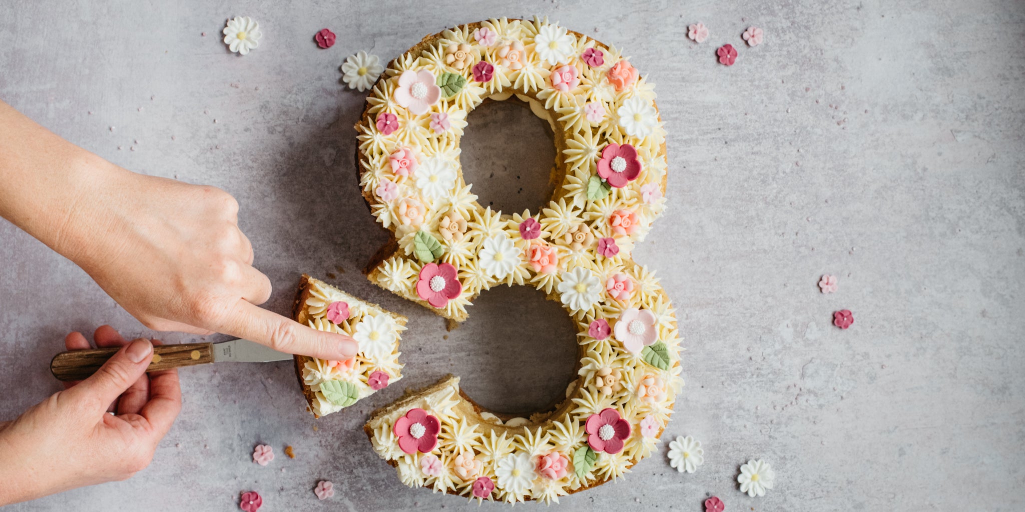 Top view of Number Cake being cut into, decorated with different piping shapes and colours