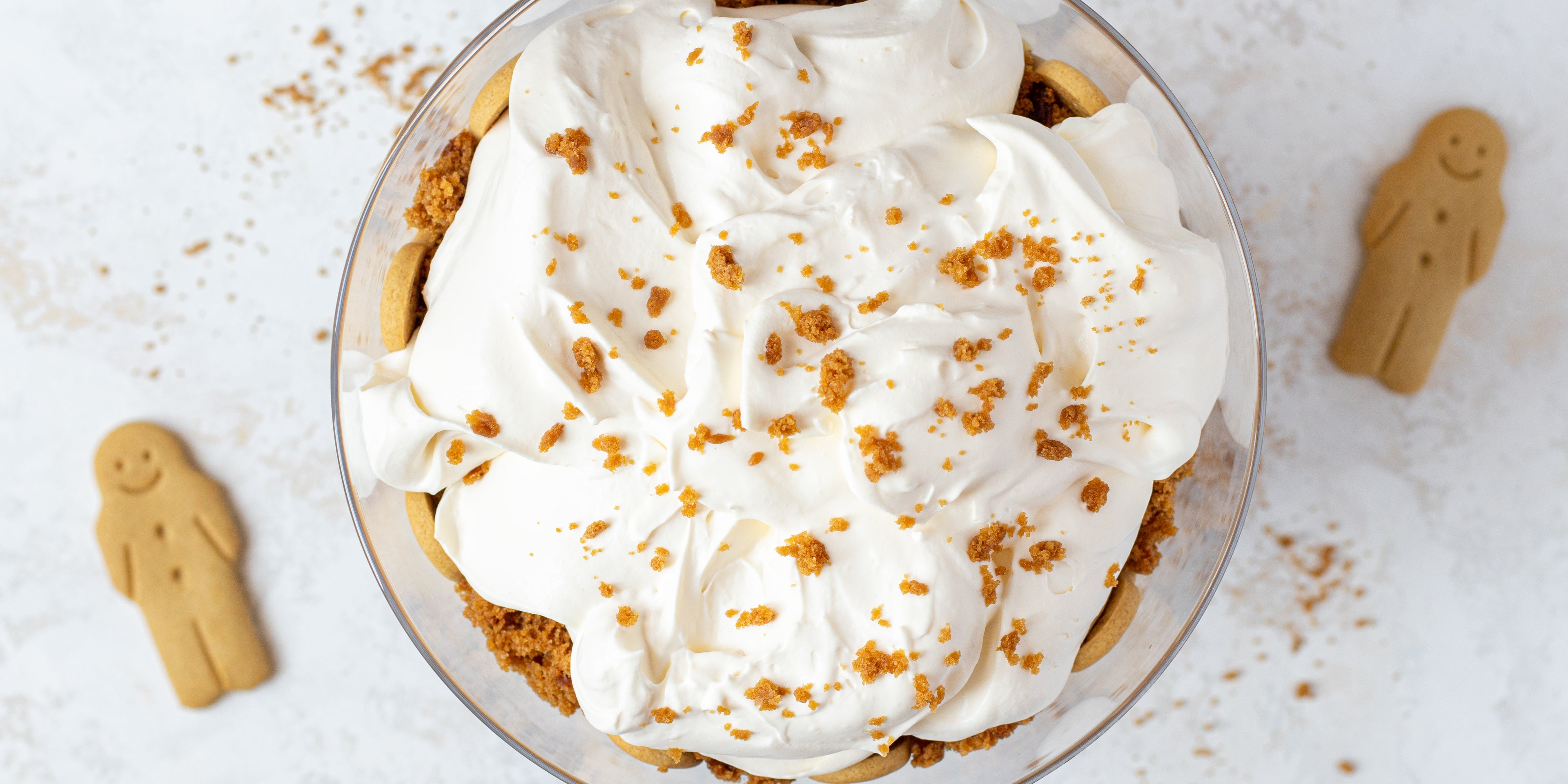 Top view of Gingerbread Trifle with a cream layer on top. Sprinkled with gingerbread crumbs and gingerbread men