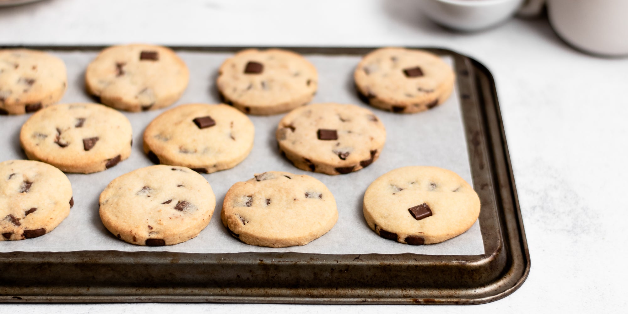 A batch of Chocolate Chunk Shortbread on a baking tray with baking paper