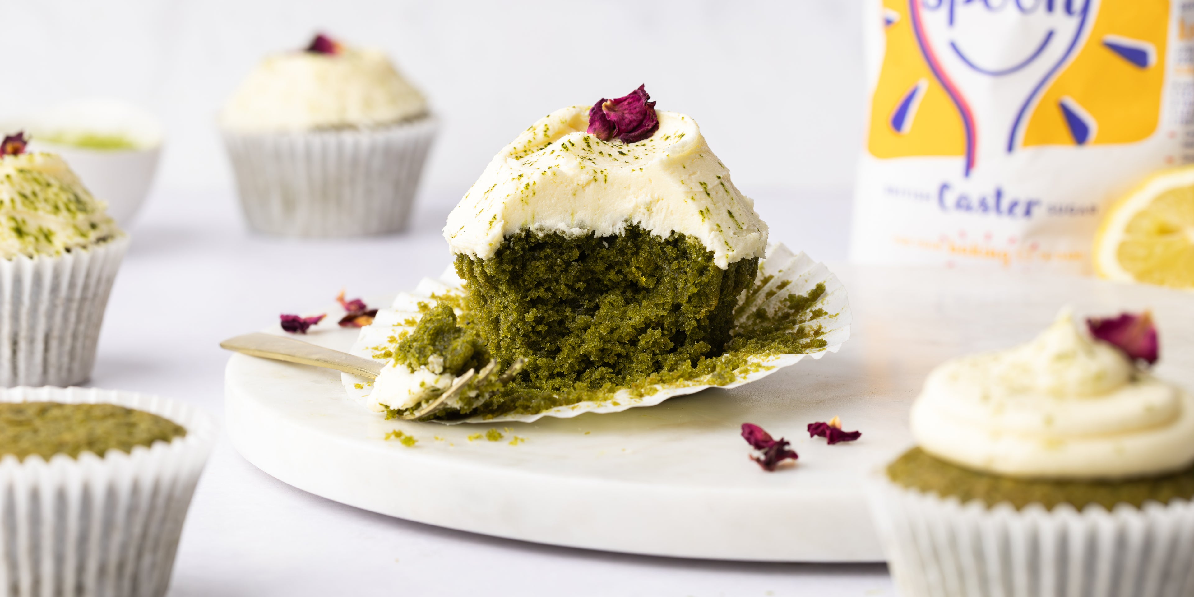 Matcha cupcake on plate with other cupcakes surrounding it