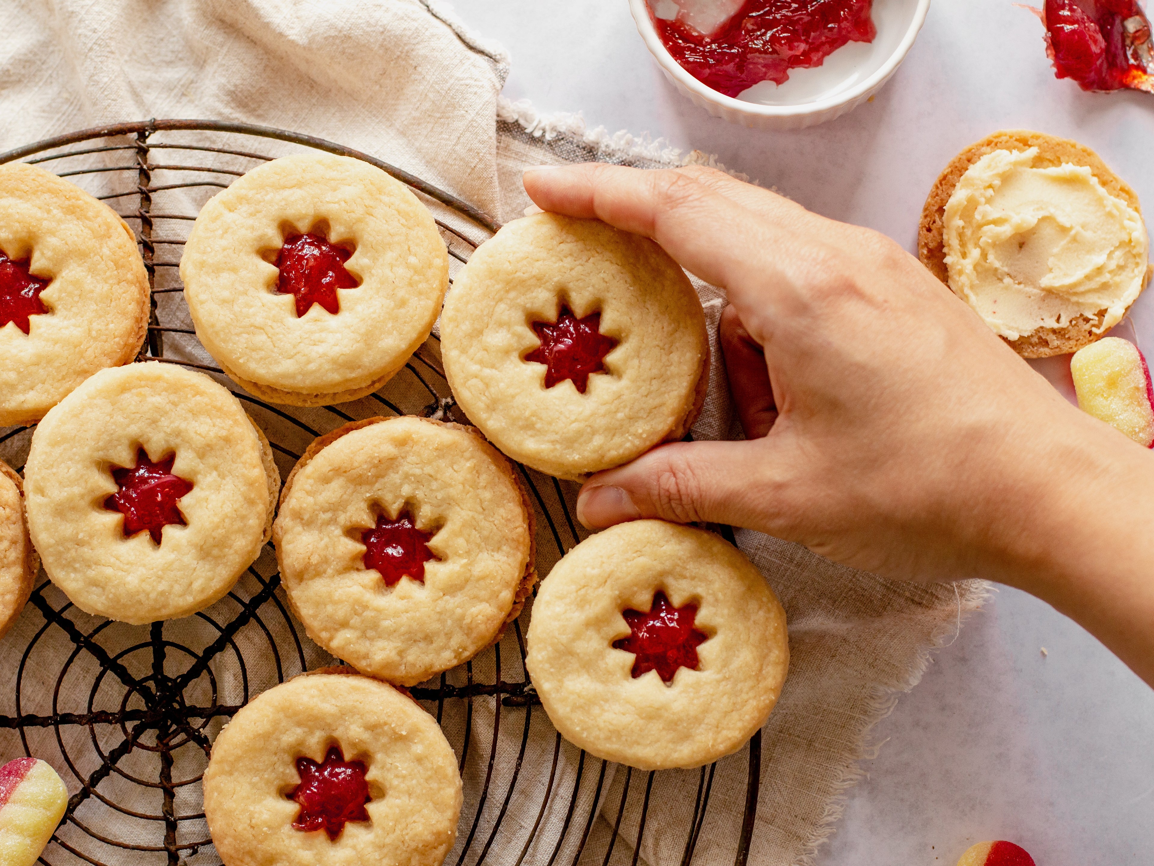 Jammy dodgers on wire cooling rack with hand