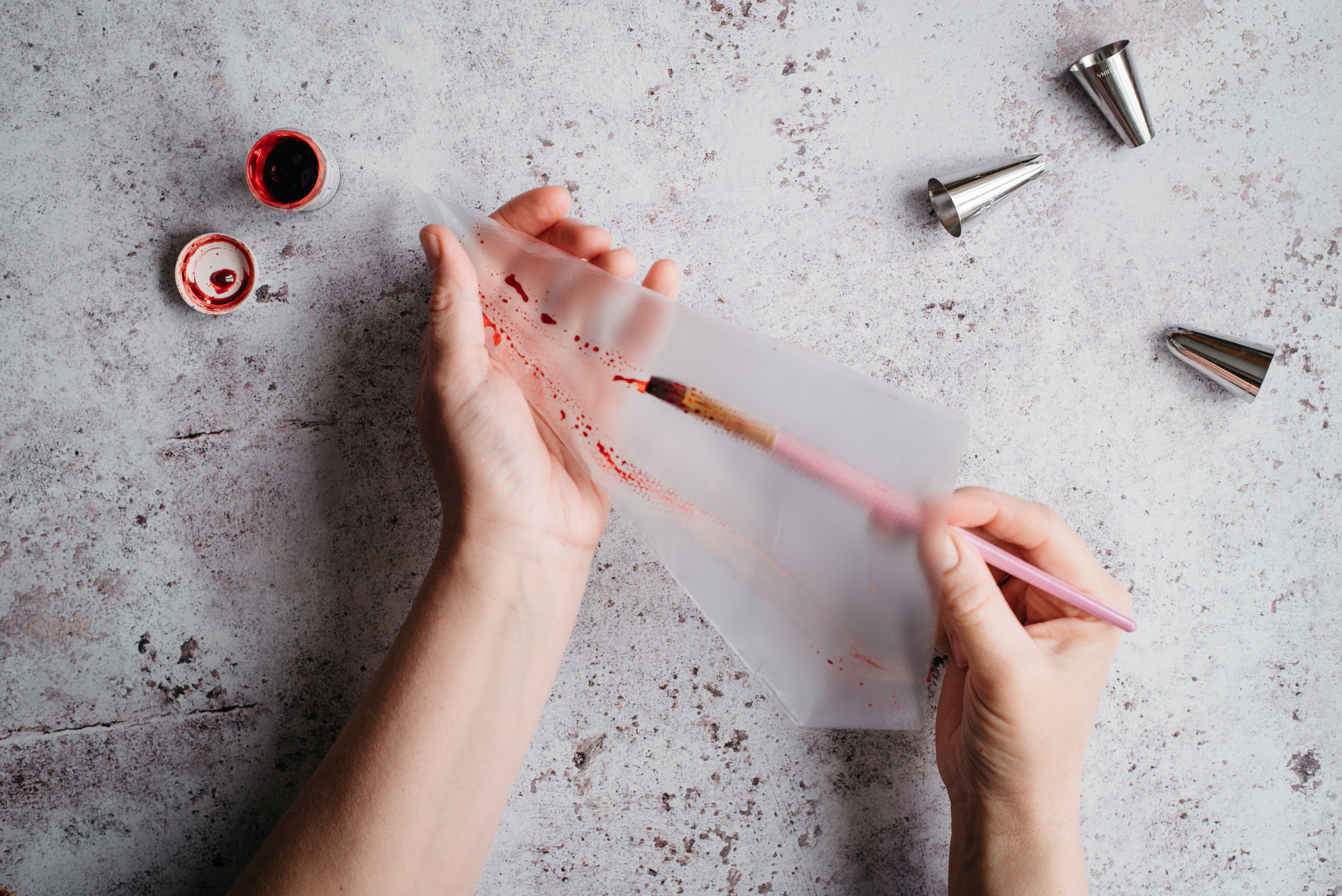 Piping bag being prepared by painting it with food colouring to give the Vegan Meringue their pink swirls