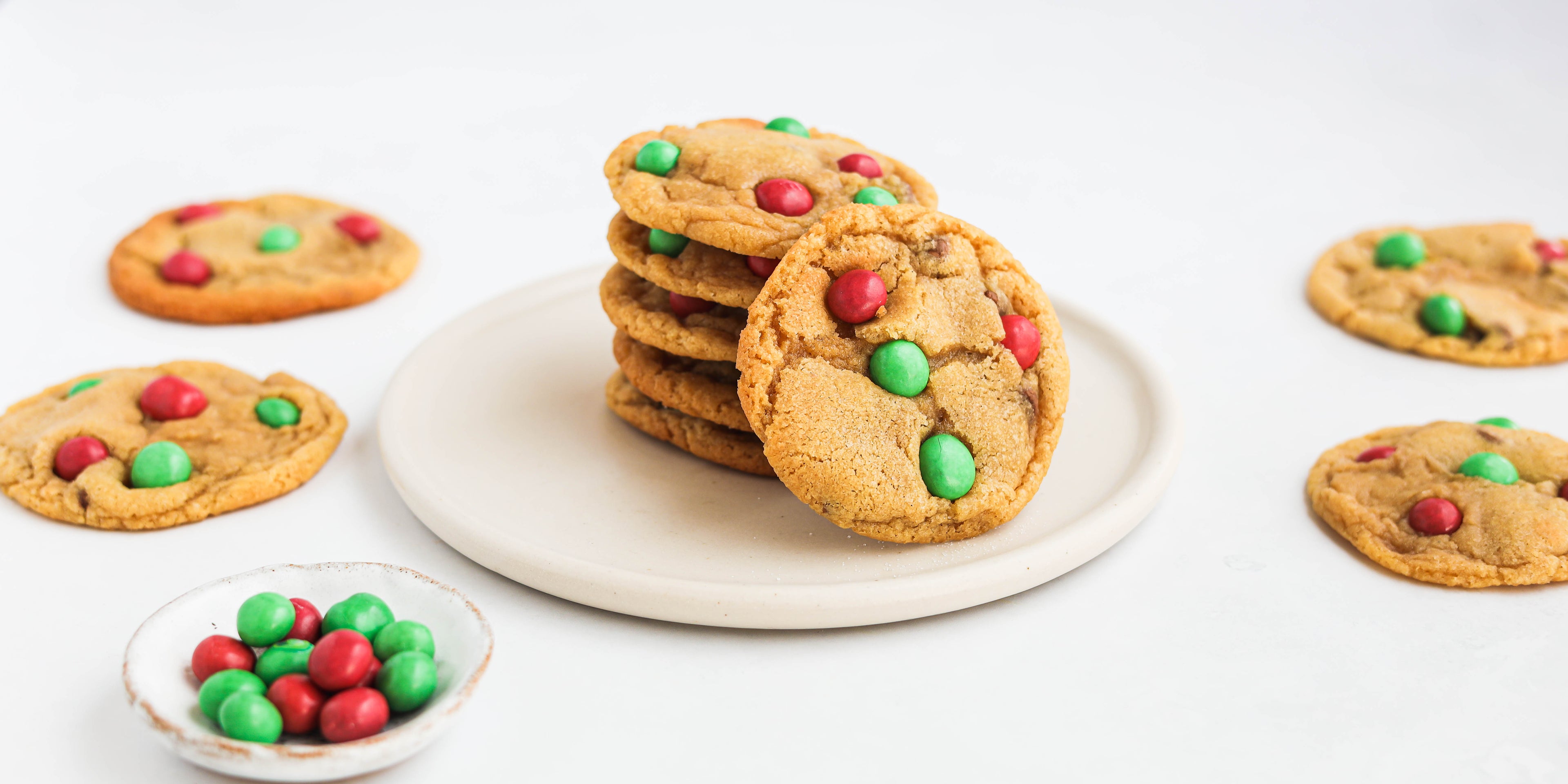 Stack of Copycat Millies Cookies with red and green m&ms for Christmas. Next to a dish of m&ms