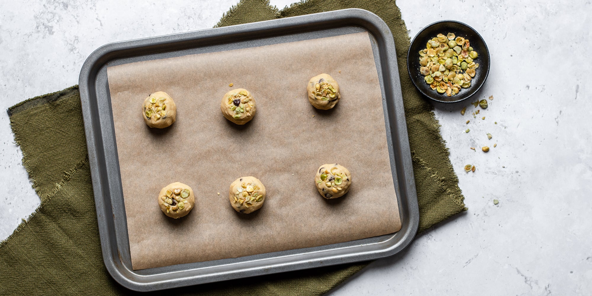 Top down view of wasabi cookie dough rolled in balls on a baking tray