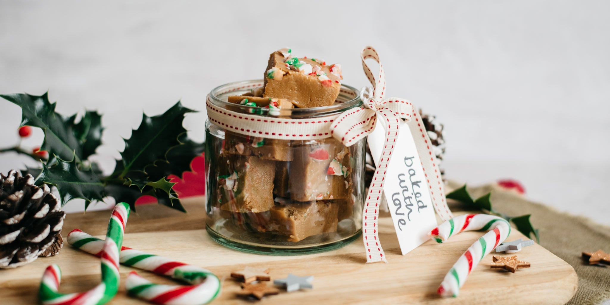 Close up of edible gifting jar of Candy Cane Fudge by Billington's with a handwritten tag and ribbon