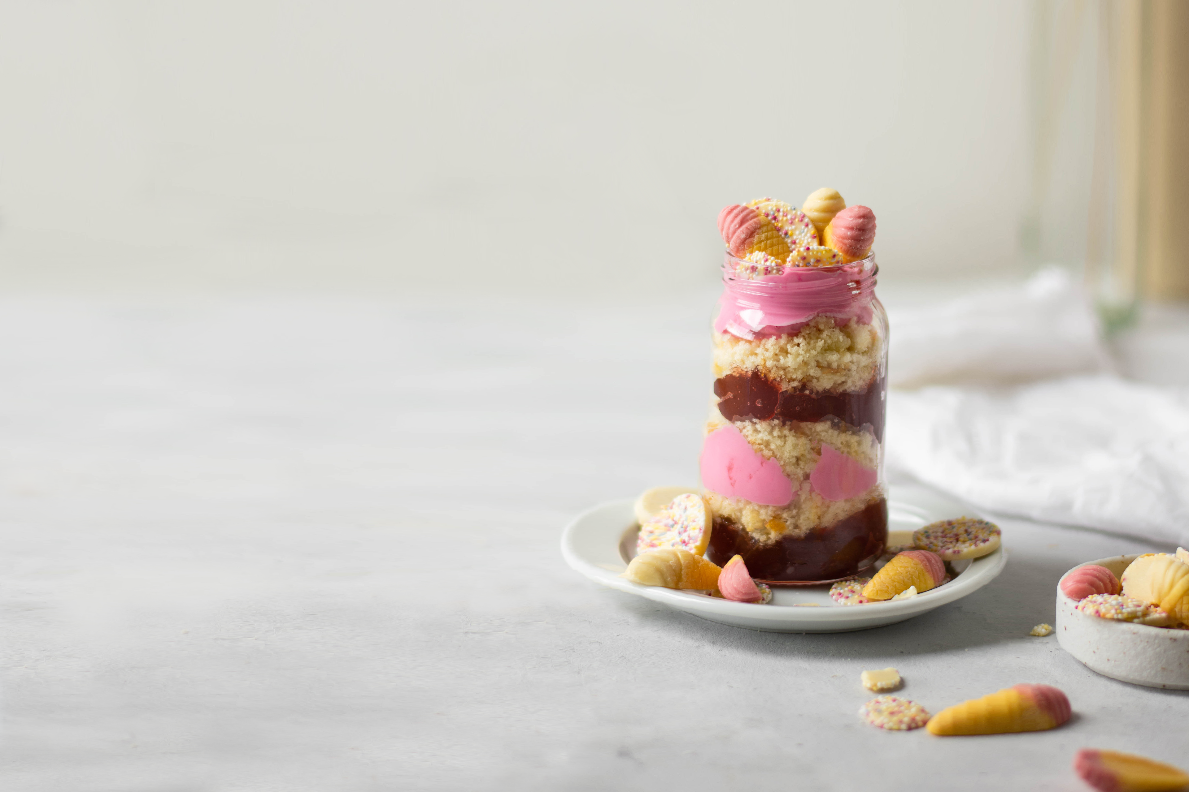 Pick'n'Mix Cake Jar on a plate with sprinkles of sweeties, and jazzies