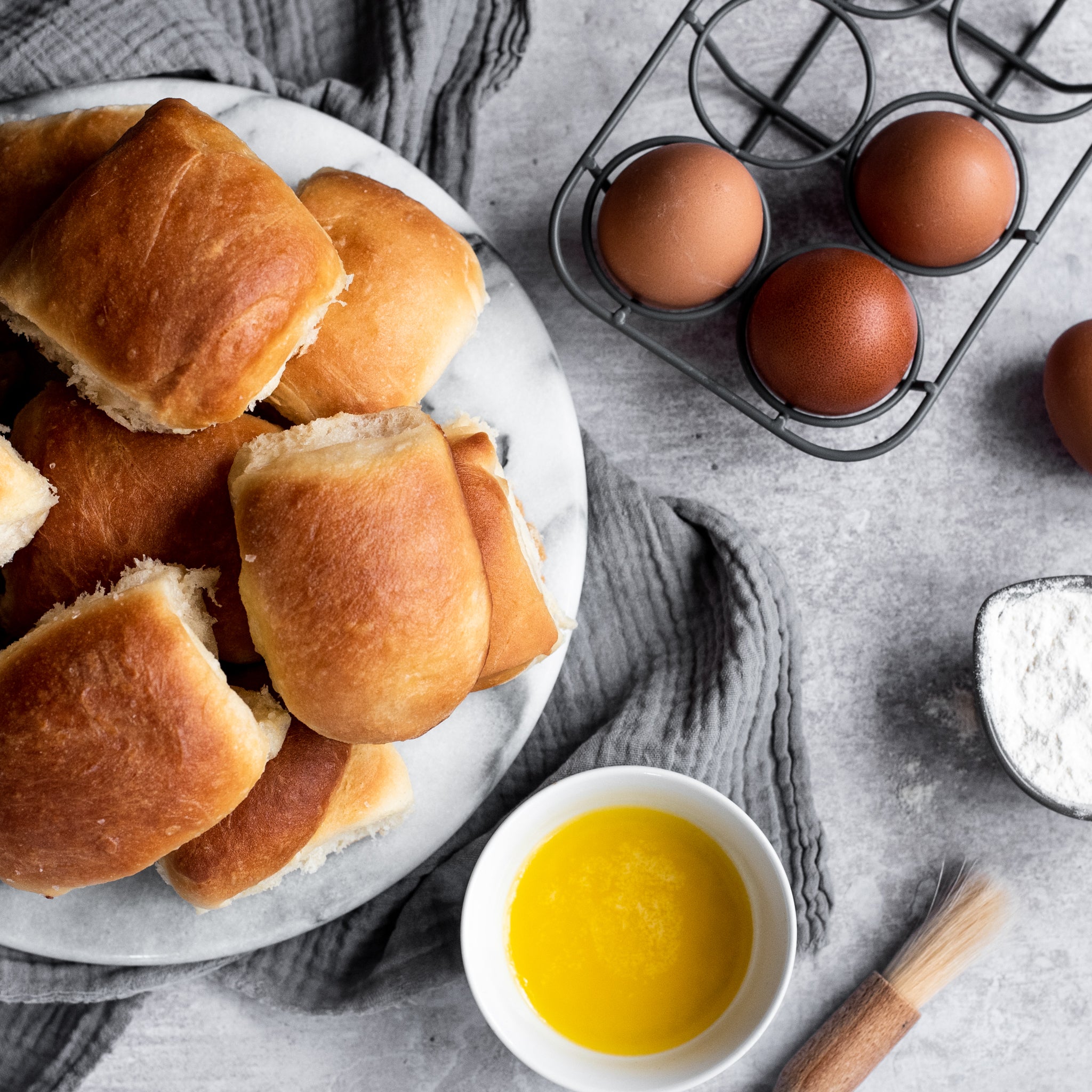 bread rolls on a plate with a side of melted butter