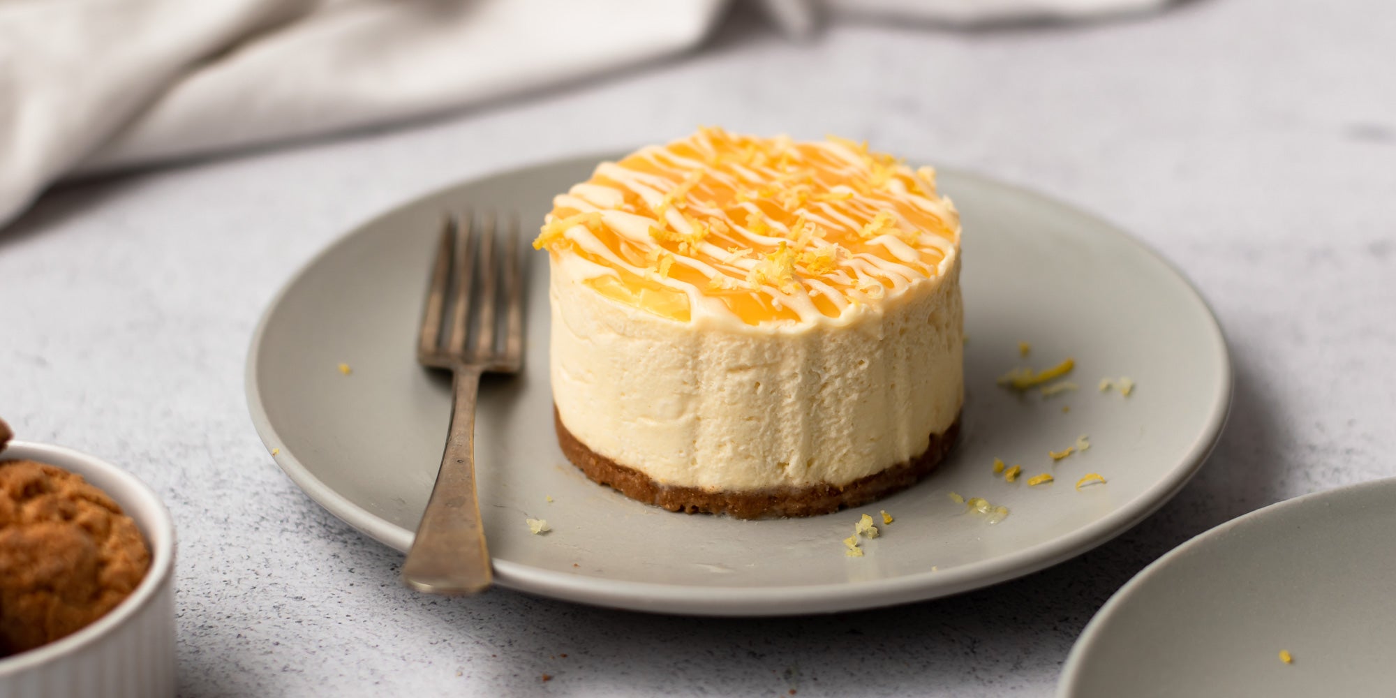 Mini Lemon Amaretti Cheesecake on a plate next to a fork