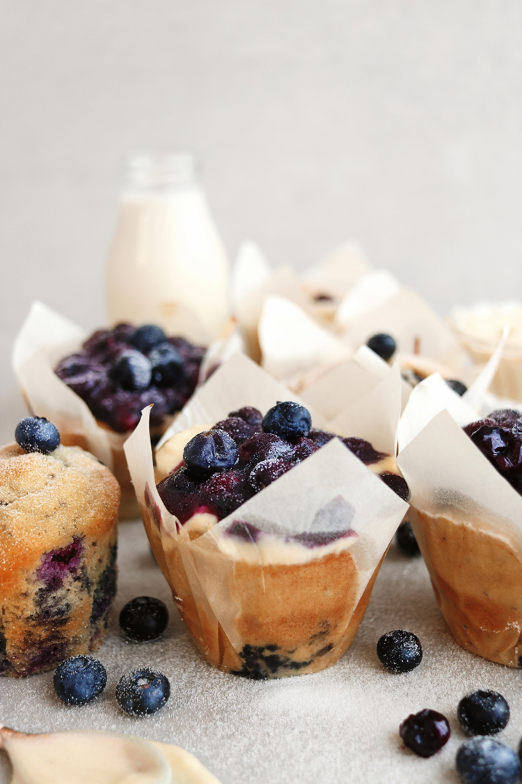 Close up of plant based blueberry and chai muffins, surrounded by fresh blueberries