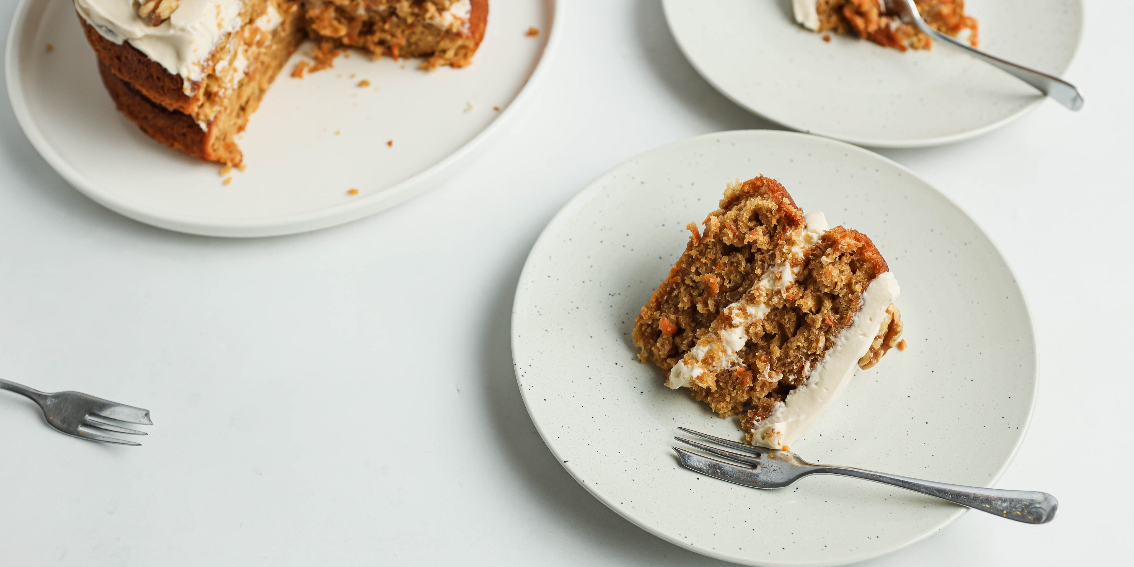 Slice of Classic Carrot Cake cut out of a slice of cake, served on a plate with a fork