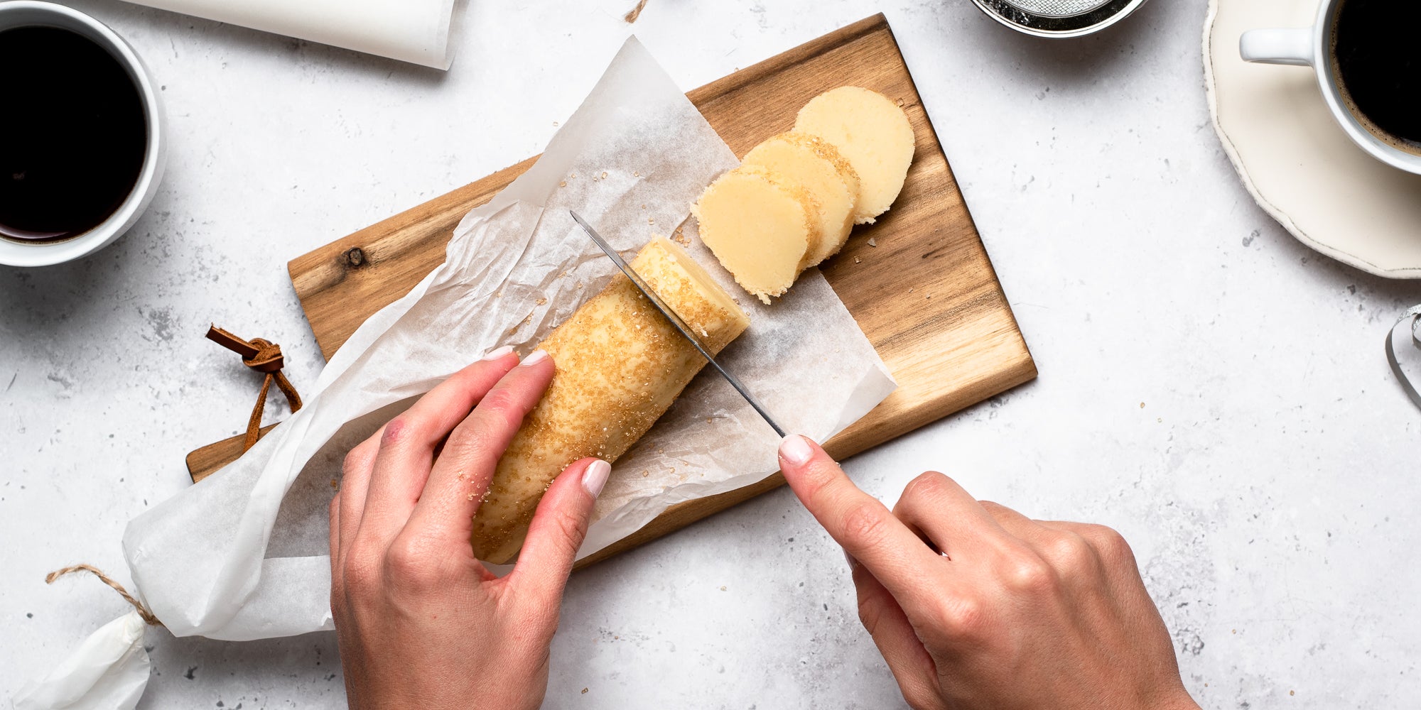 Top down view of the hand slicing through vegan shortbread dough