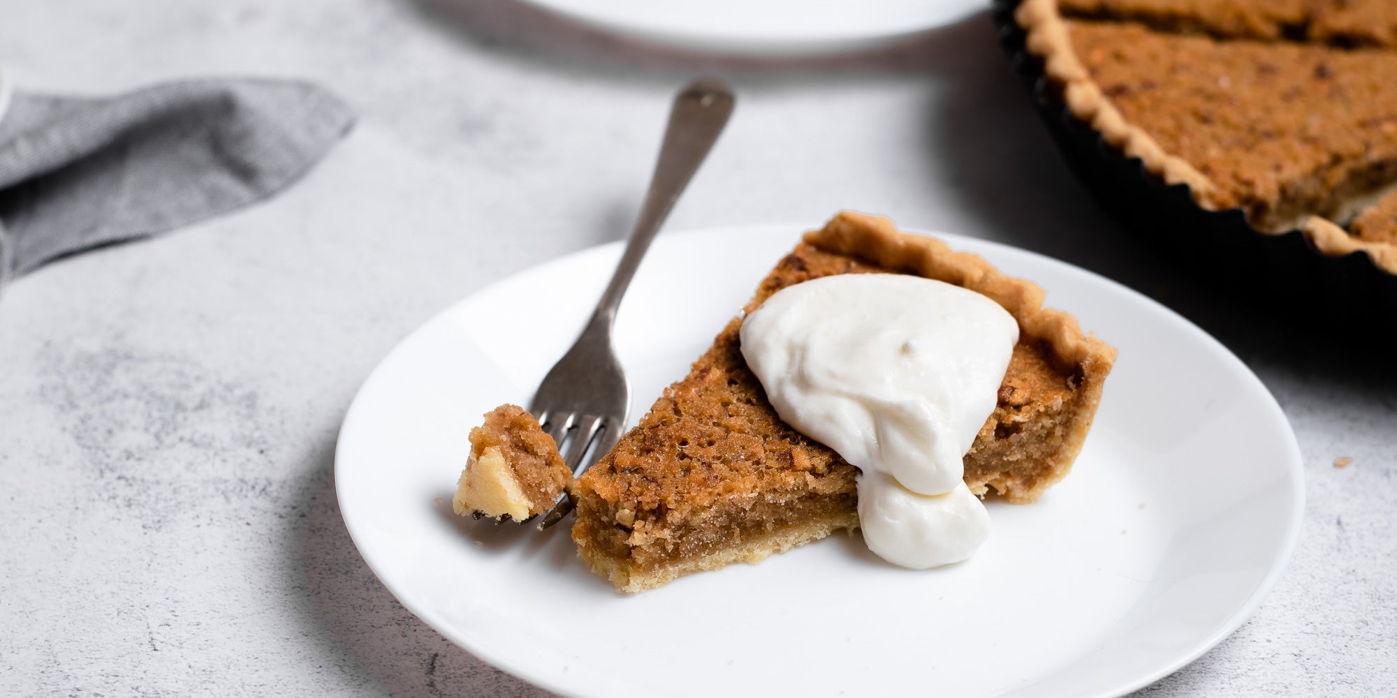 Treacle Tart on a plate with fork and dollop of cream