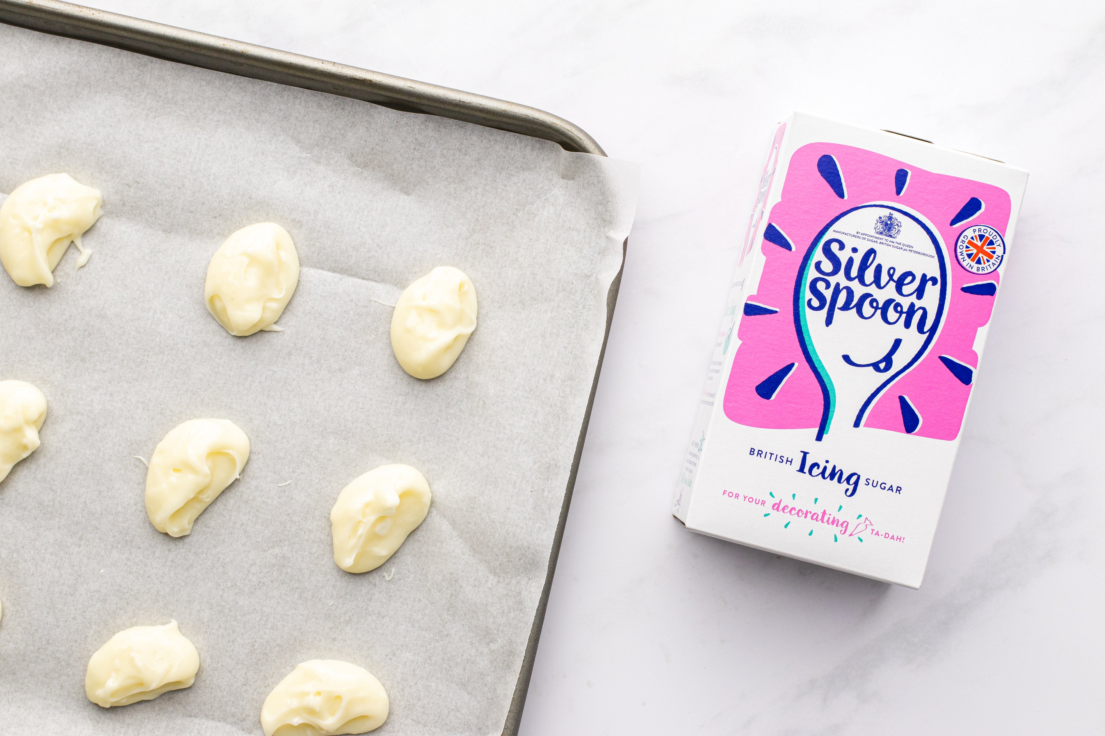 Baking tray with blobs of filling and a silver spoon icing pack