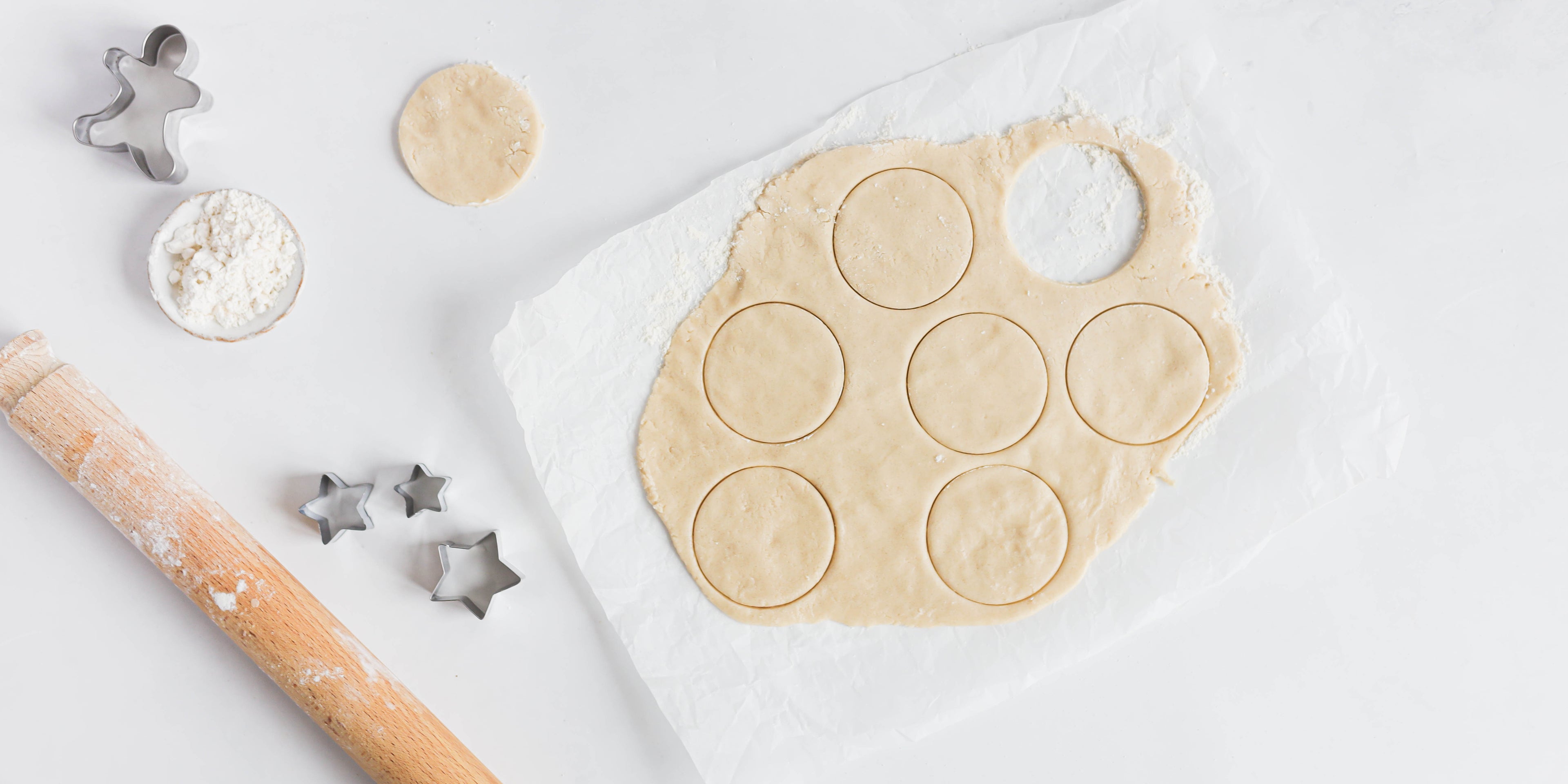 Vegan dough rolled out with circles cut out of it