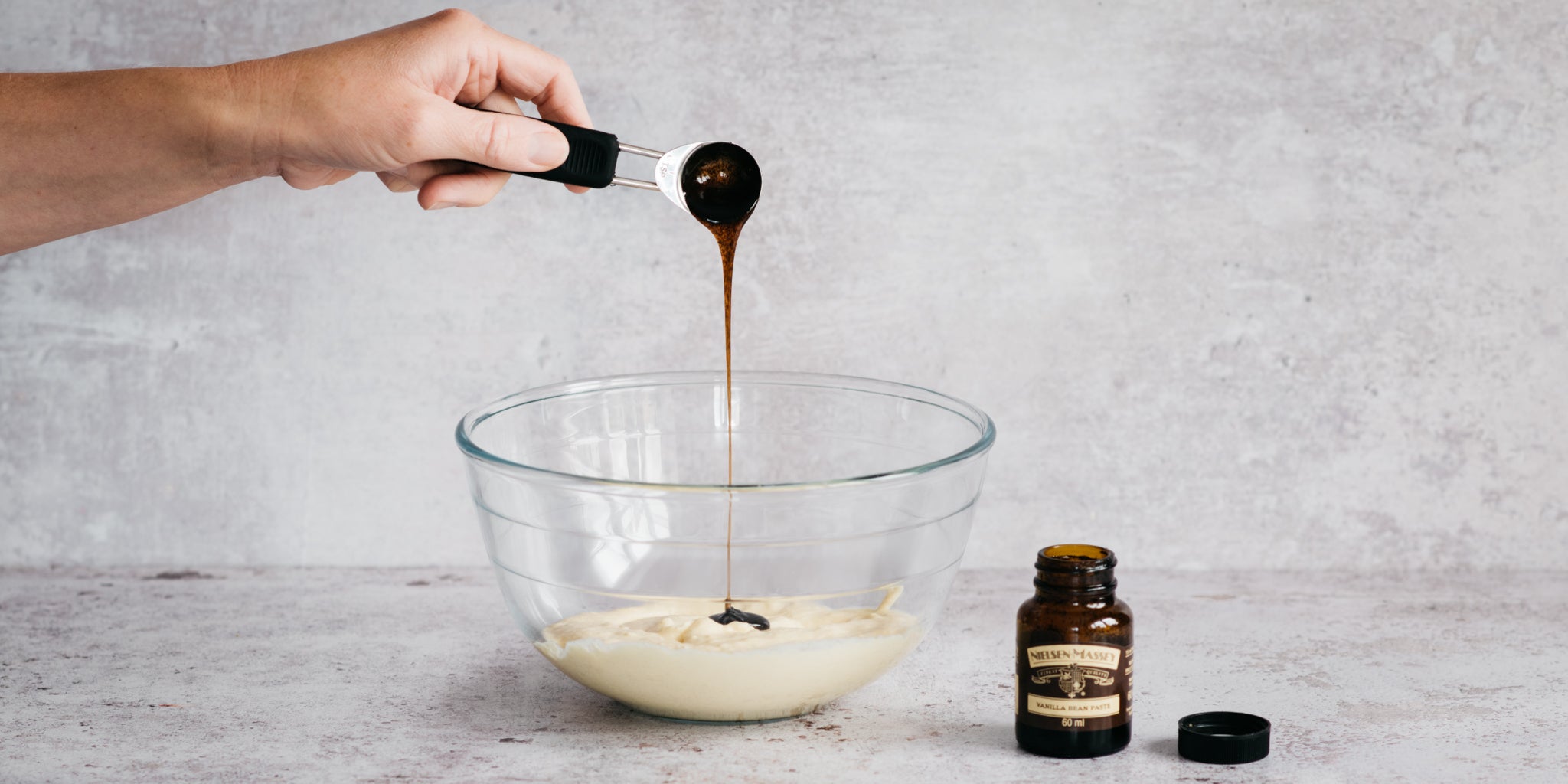 Vegan Vanilla Cake mixture being added to a bowl, with a generous helping of Nielsen Massey Vanilla paste