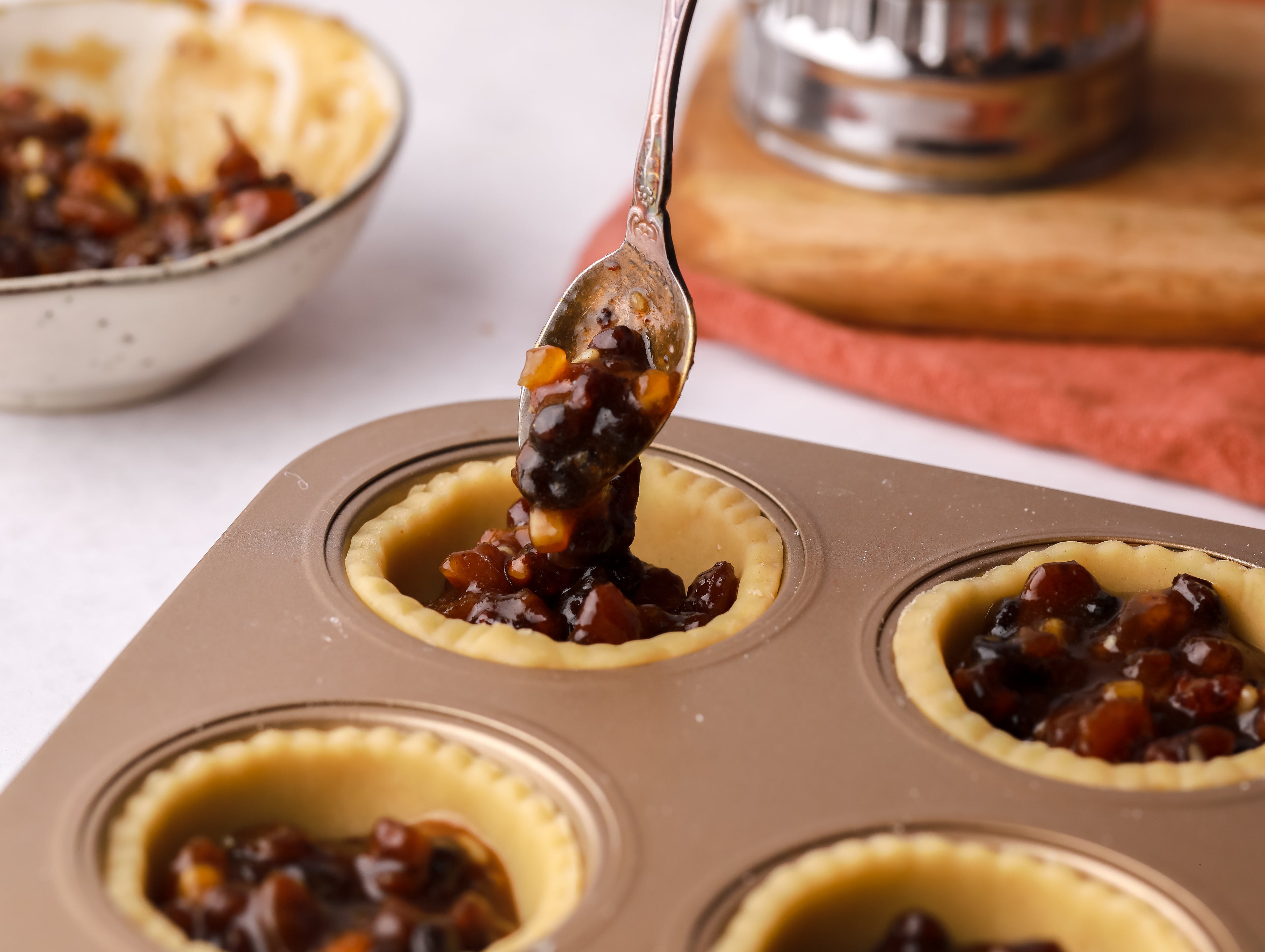 Hand spooning in mincemeat to pastry cases