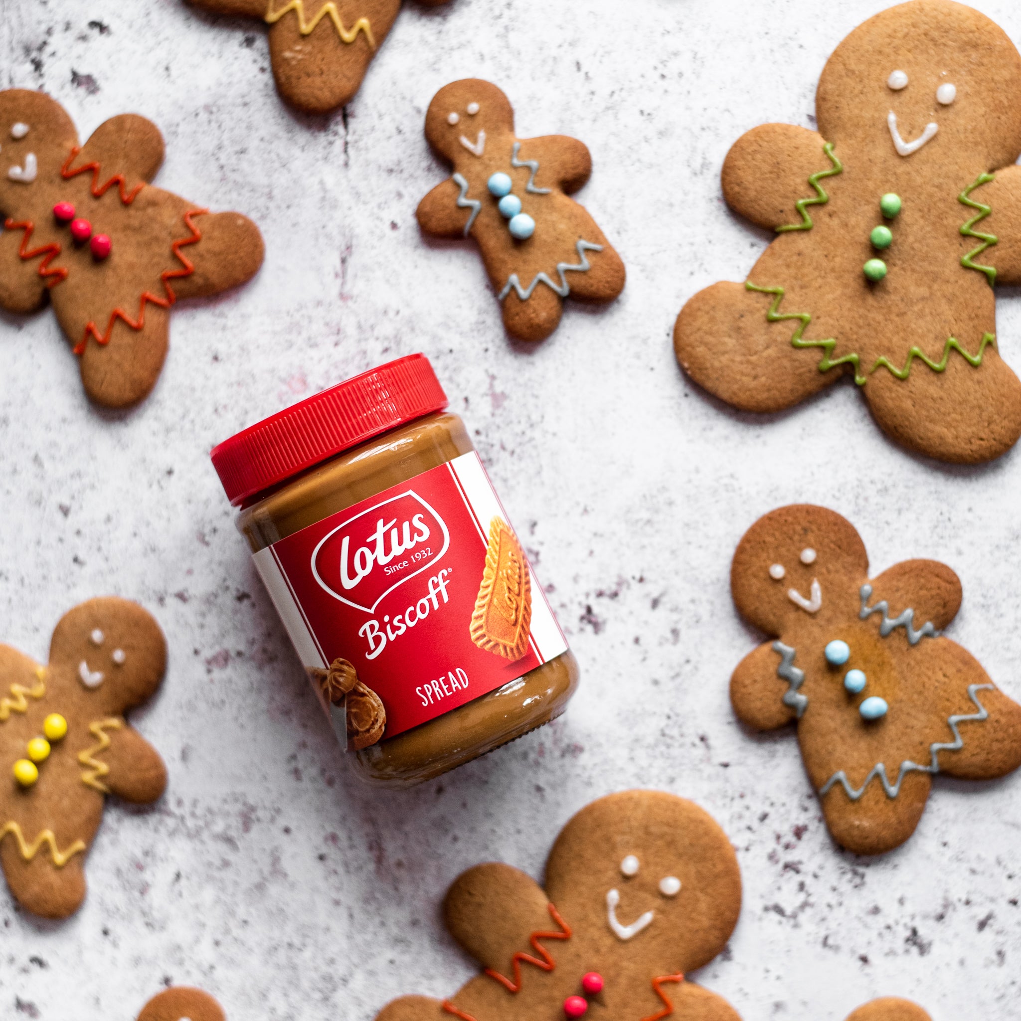 Gingerbread men lying next to a jar of Lotus Biscoff spread