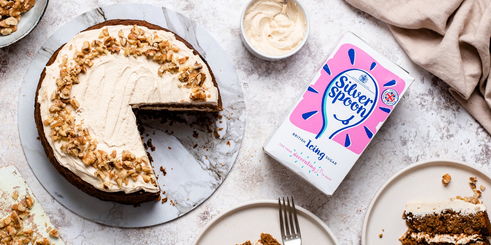 Flat lay picture of Gluten Free Vegan Coffee Cake with a slice cut out of it next to a box of silver spoon icing sugar