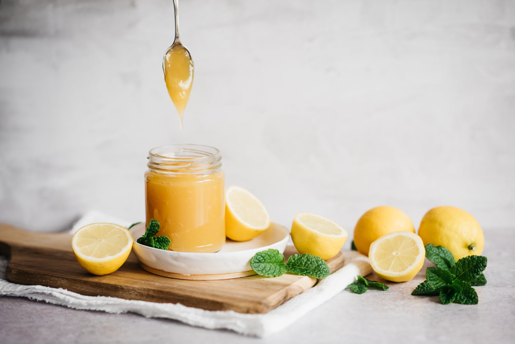 Lemon Curd in a jar next to lemons