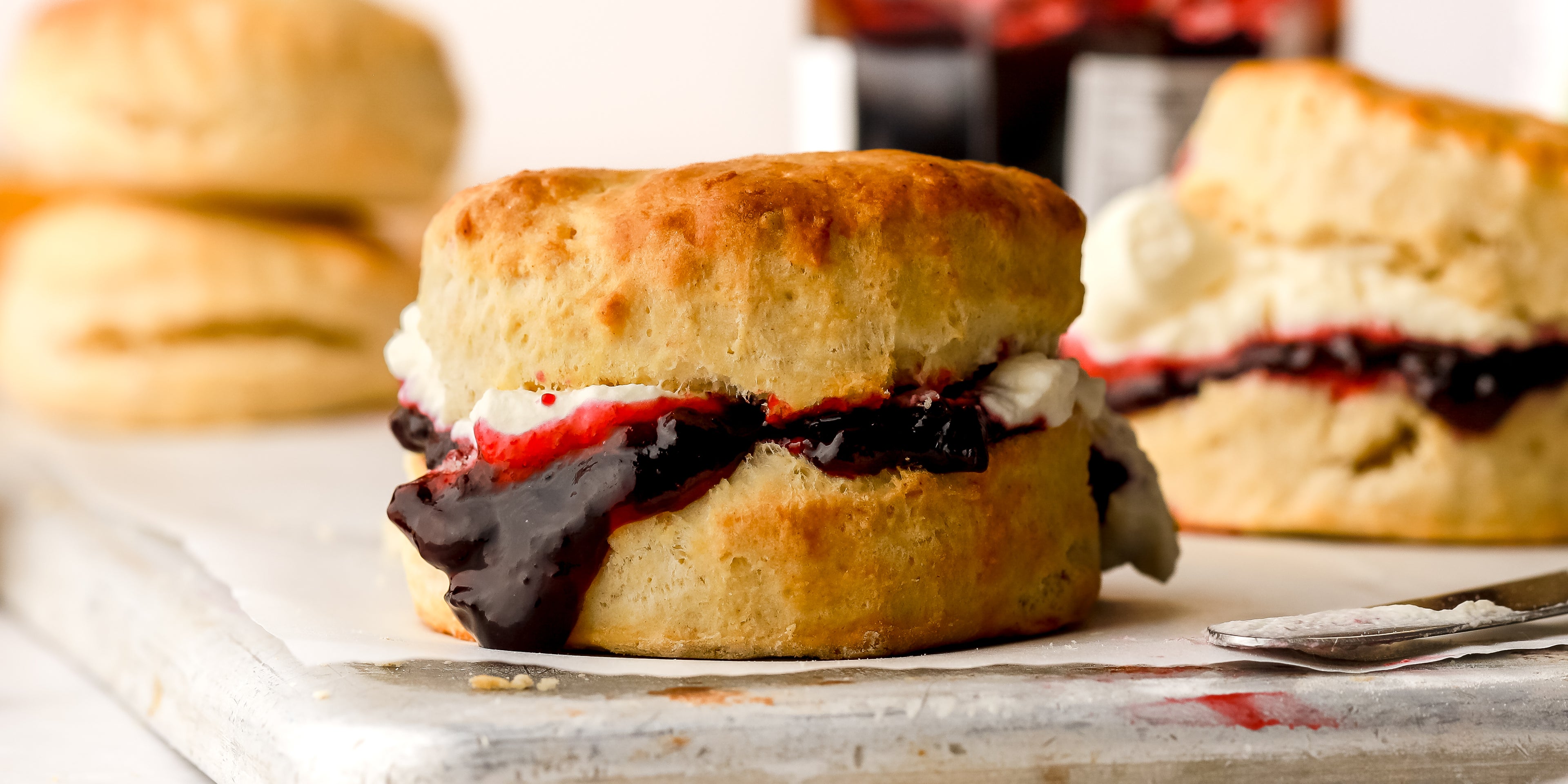 Close up of scones with jam and cream oozing out