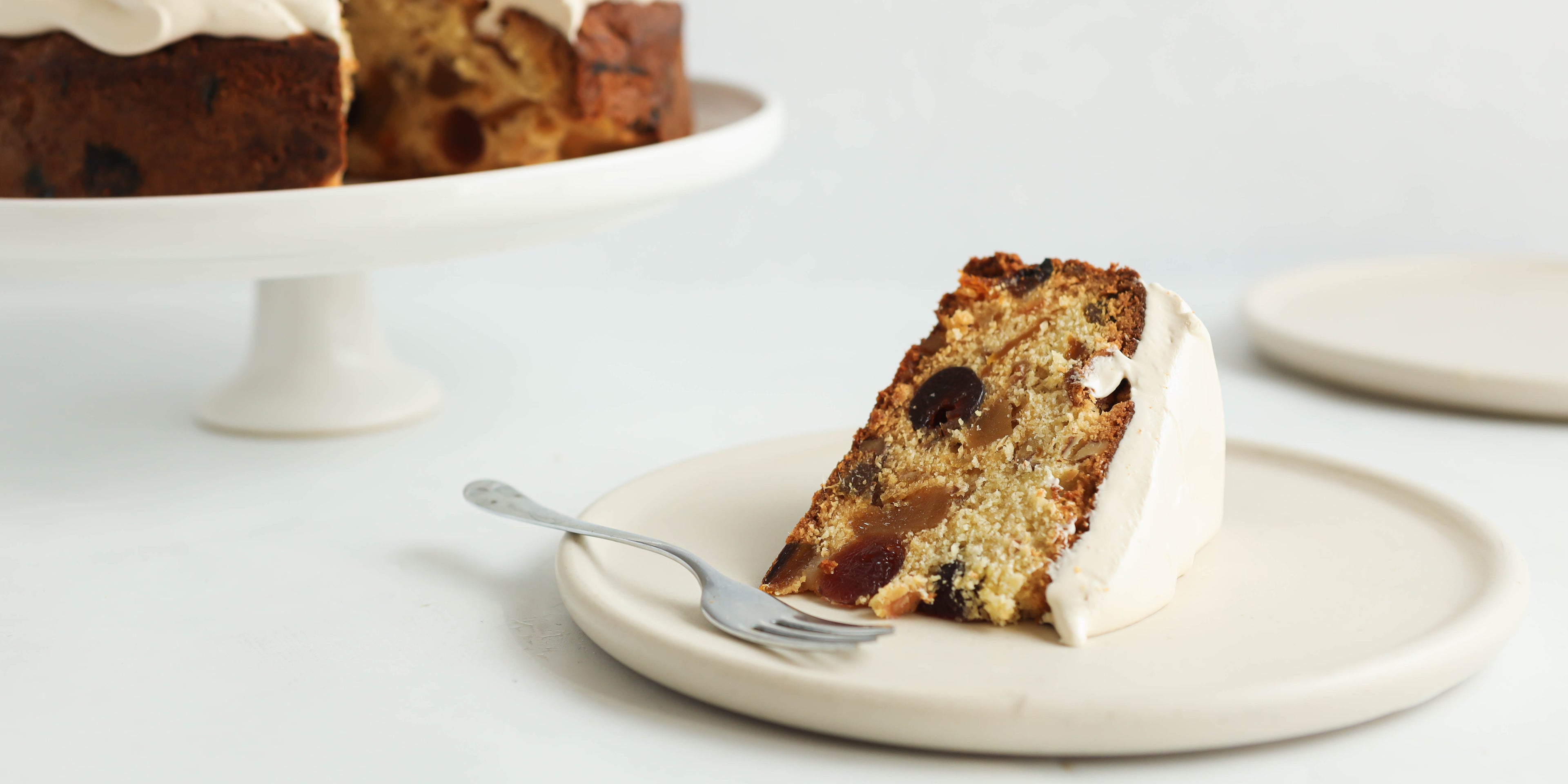 Slice of Fruit Cake served on a plate, topped with Billington's Golden Icing, showing the fruit filled layer