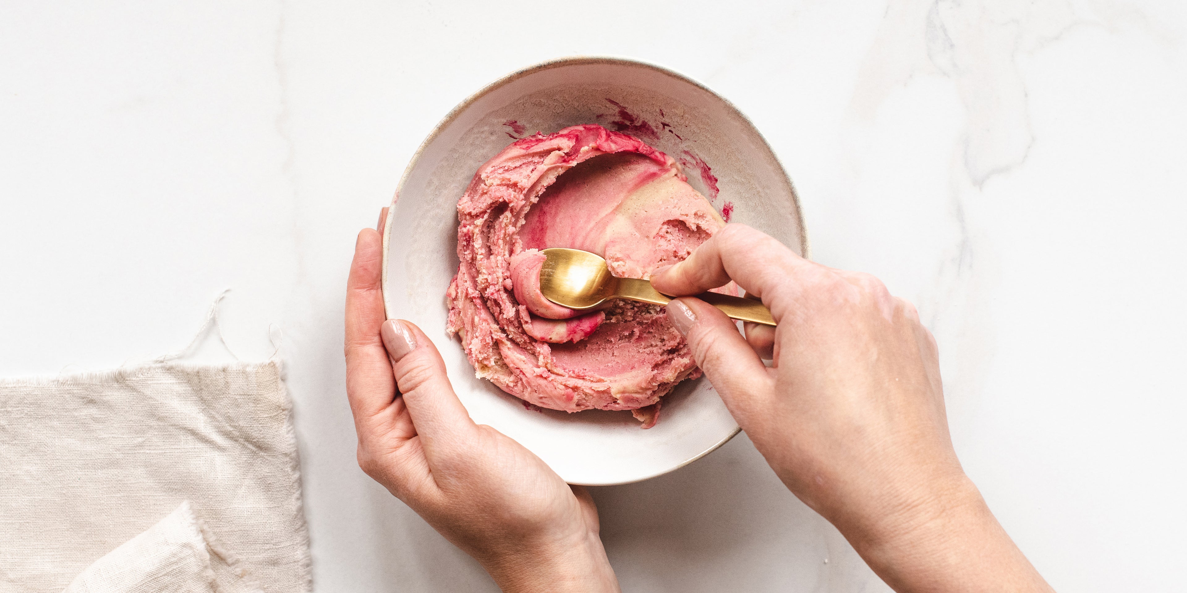 Hands holding a bowl, mixing up the pink layer to apply to the Conchas and decorate.