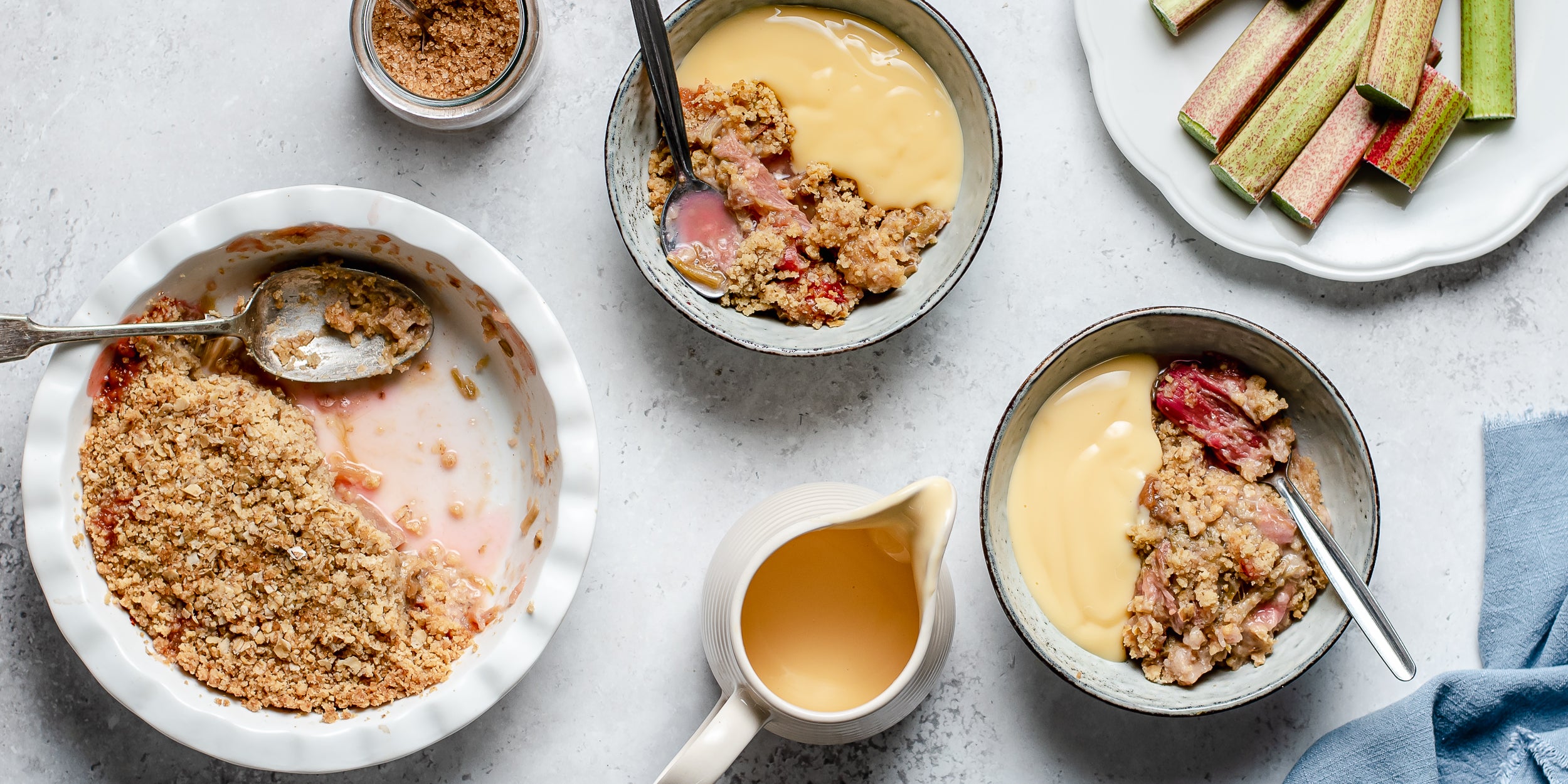Top view of Rhubarb Crumble served in dishes with a generous dollop of vanilla custard