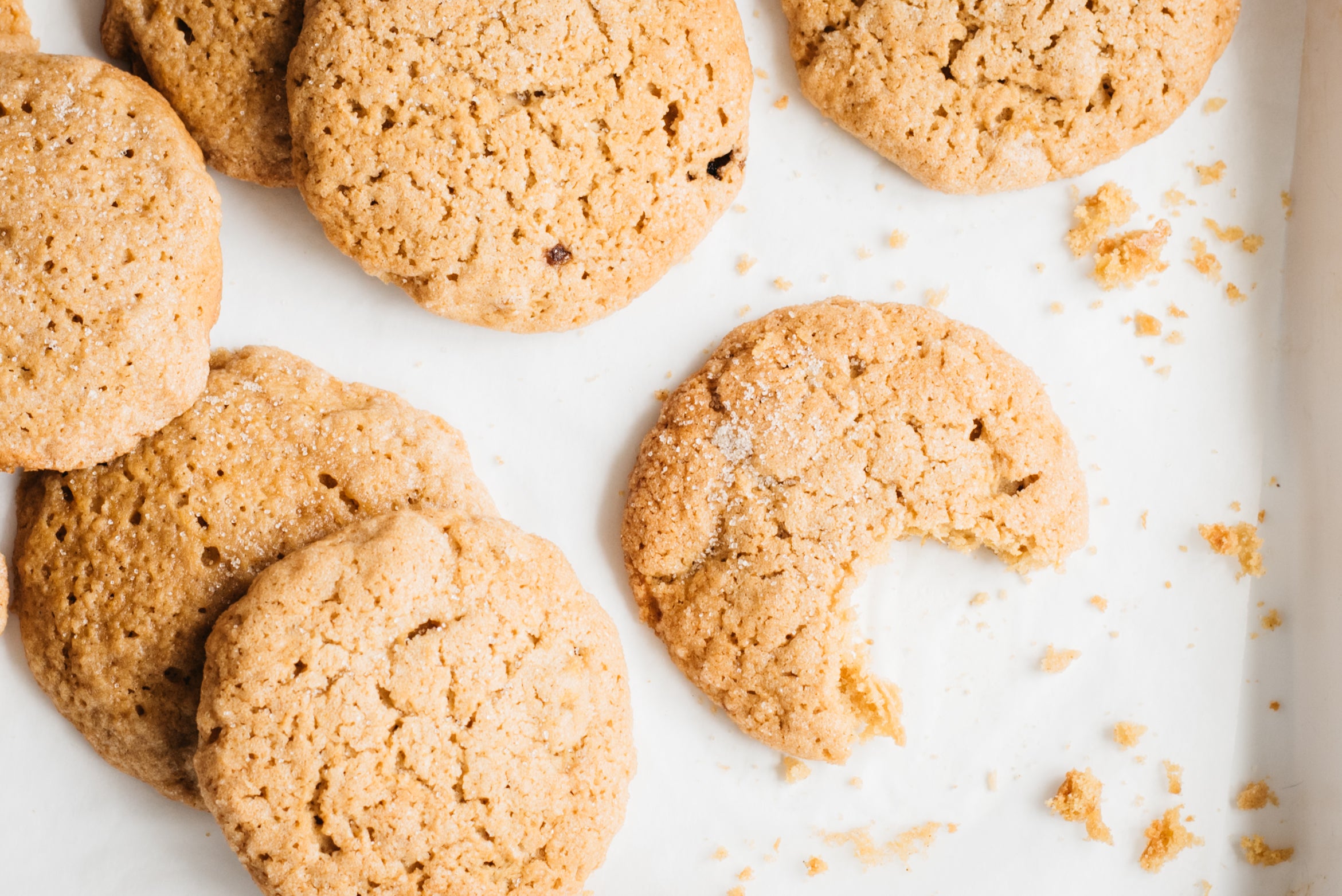 Pumpkin cookies on a baking tray with a bite taken out of it