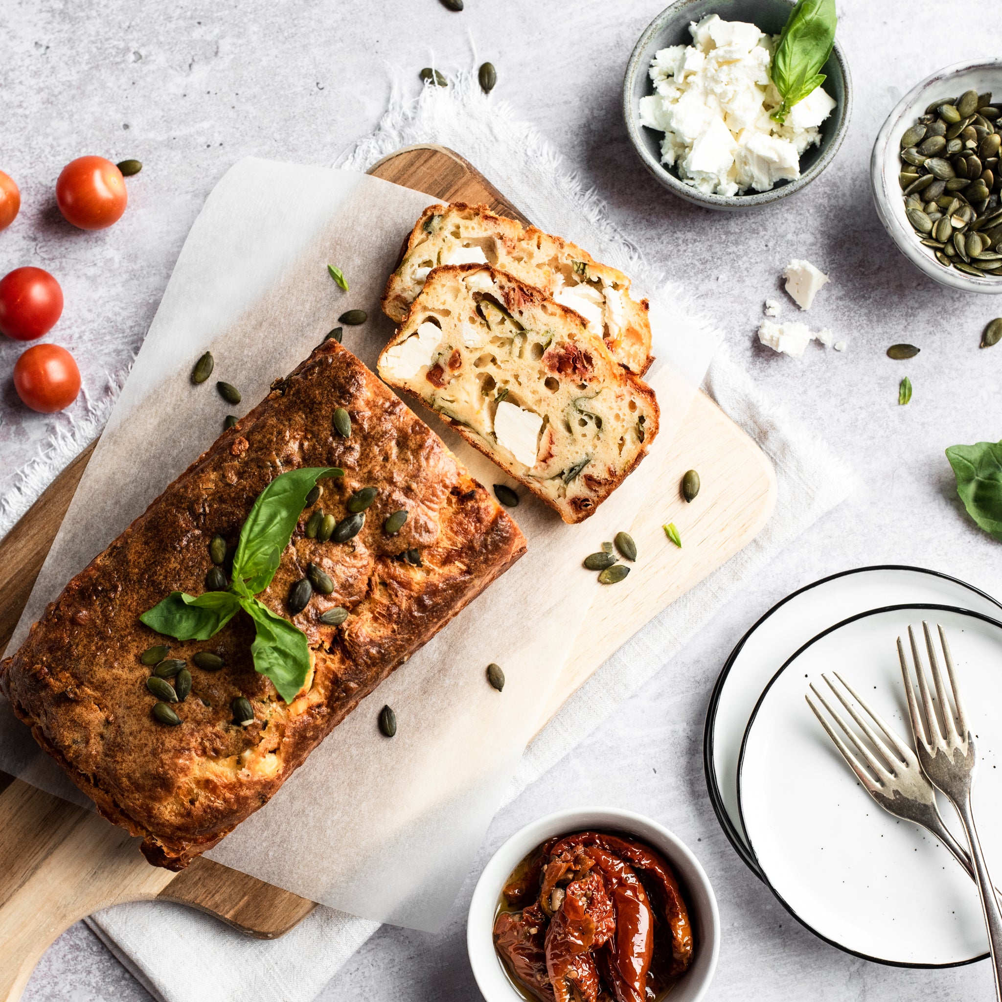 Feta and tomato loaf with slice removed on a chopping board