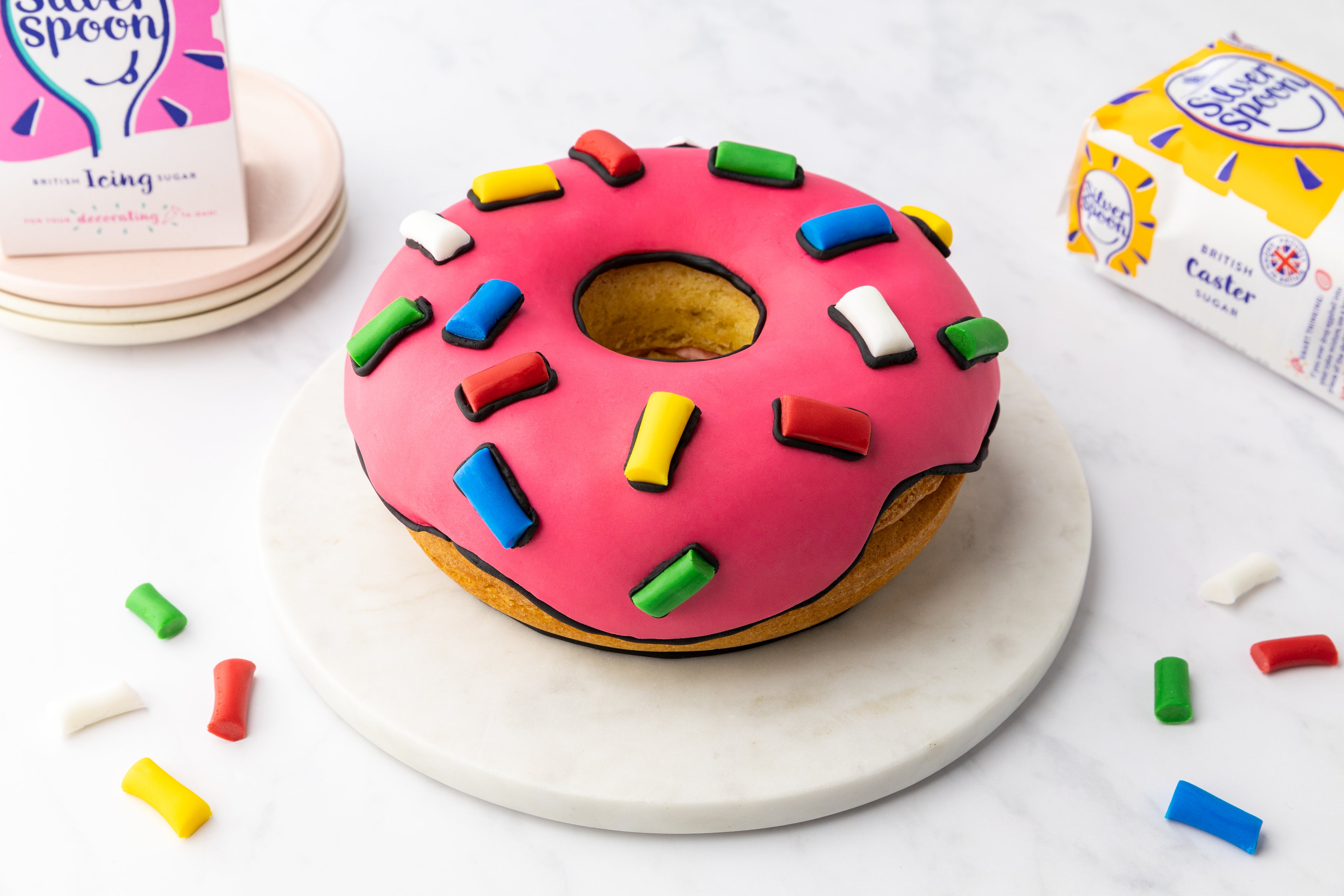 Cake designed like a doughnut with sugar packs in background