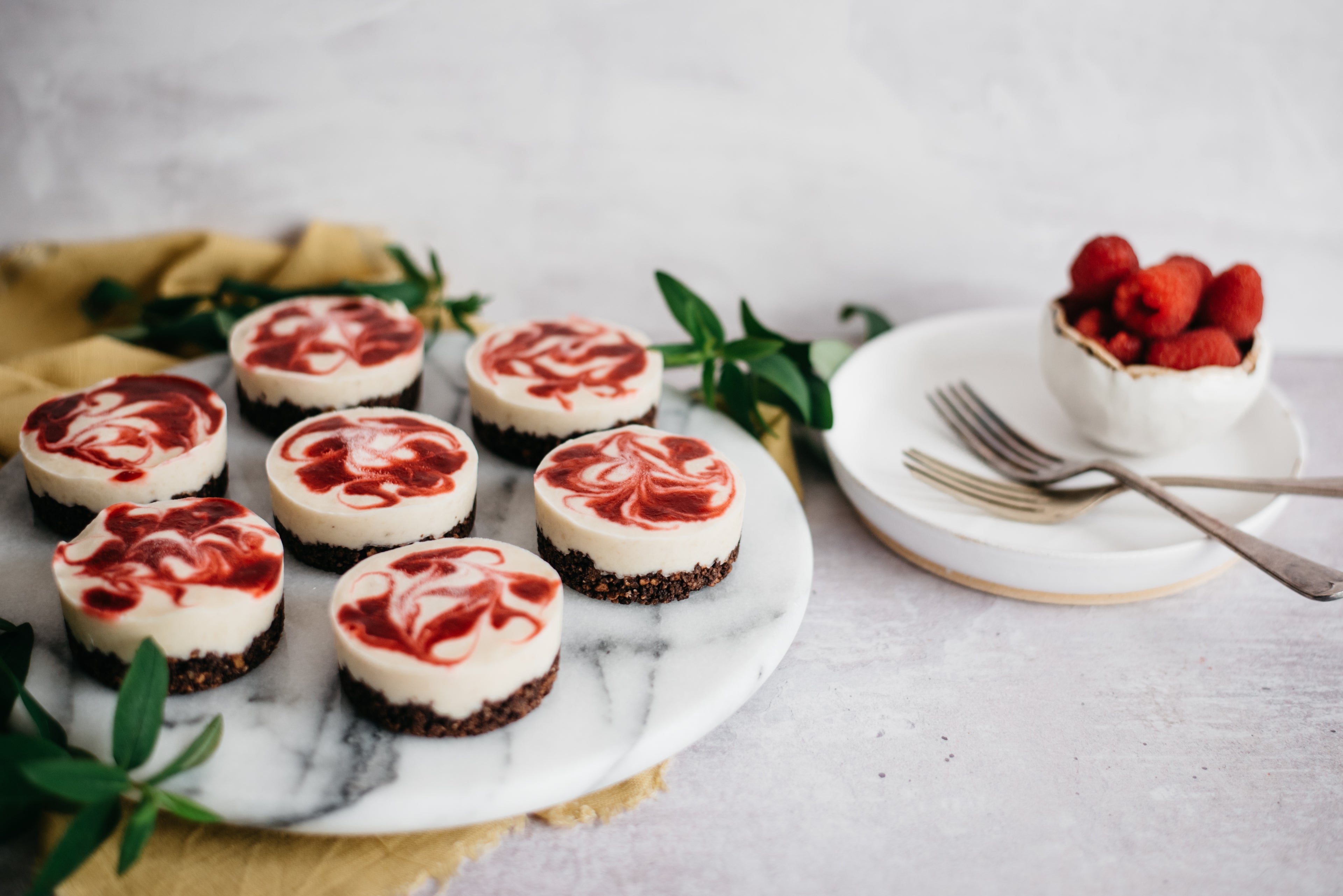 Side view of 7 vegan raspberry and banana cheesecake cups
