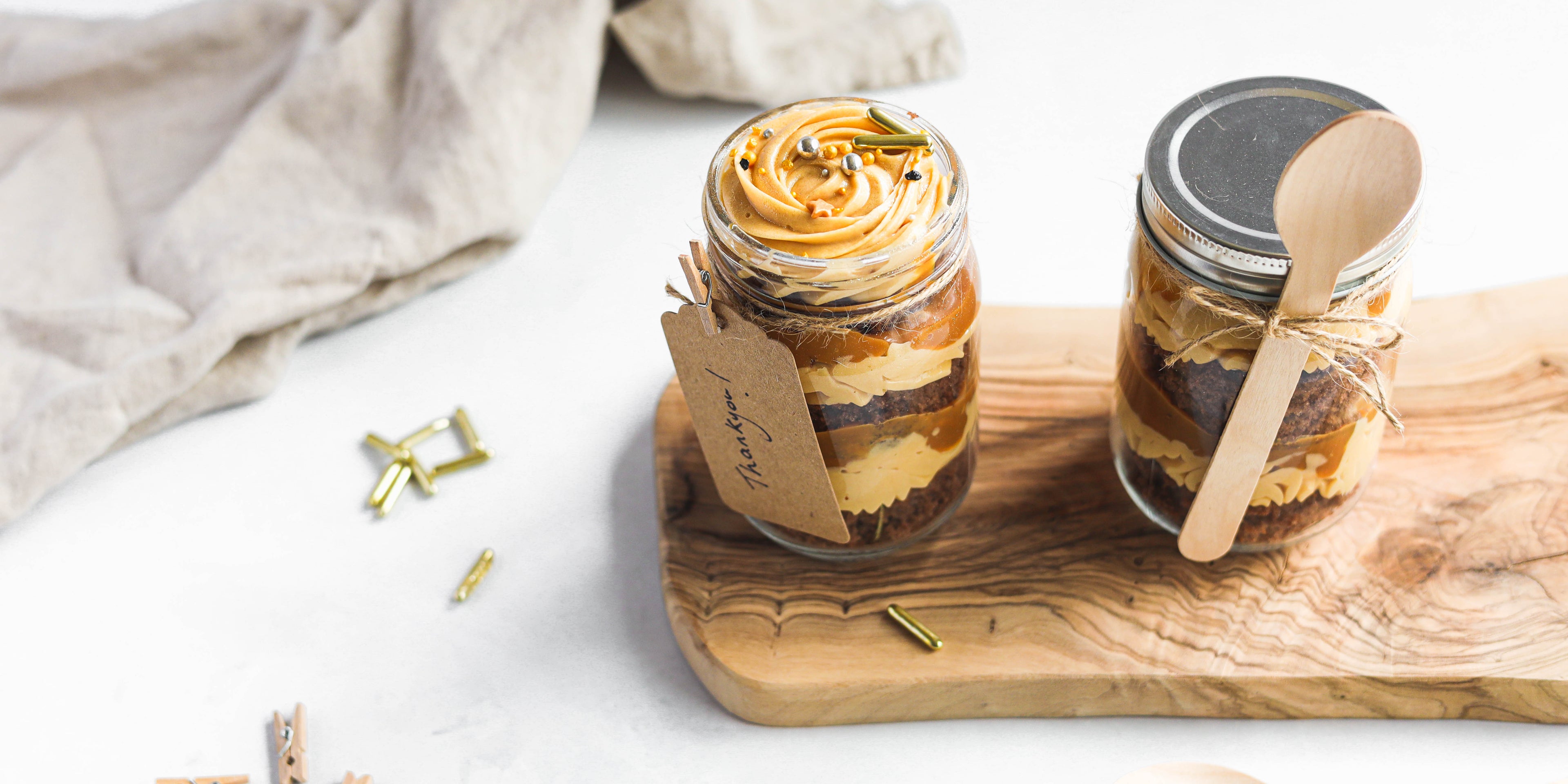 Chocolate & Salted Caramel Cupcakes in a Jar on a serving board with sprinkles and a handwritten note