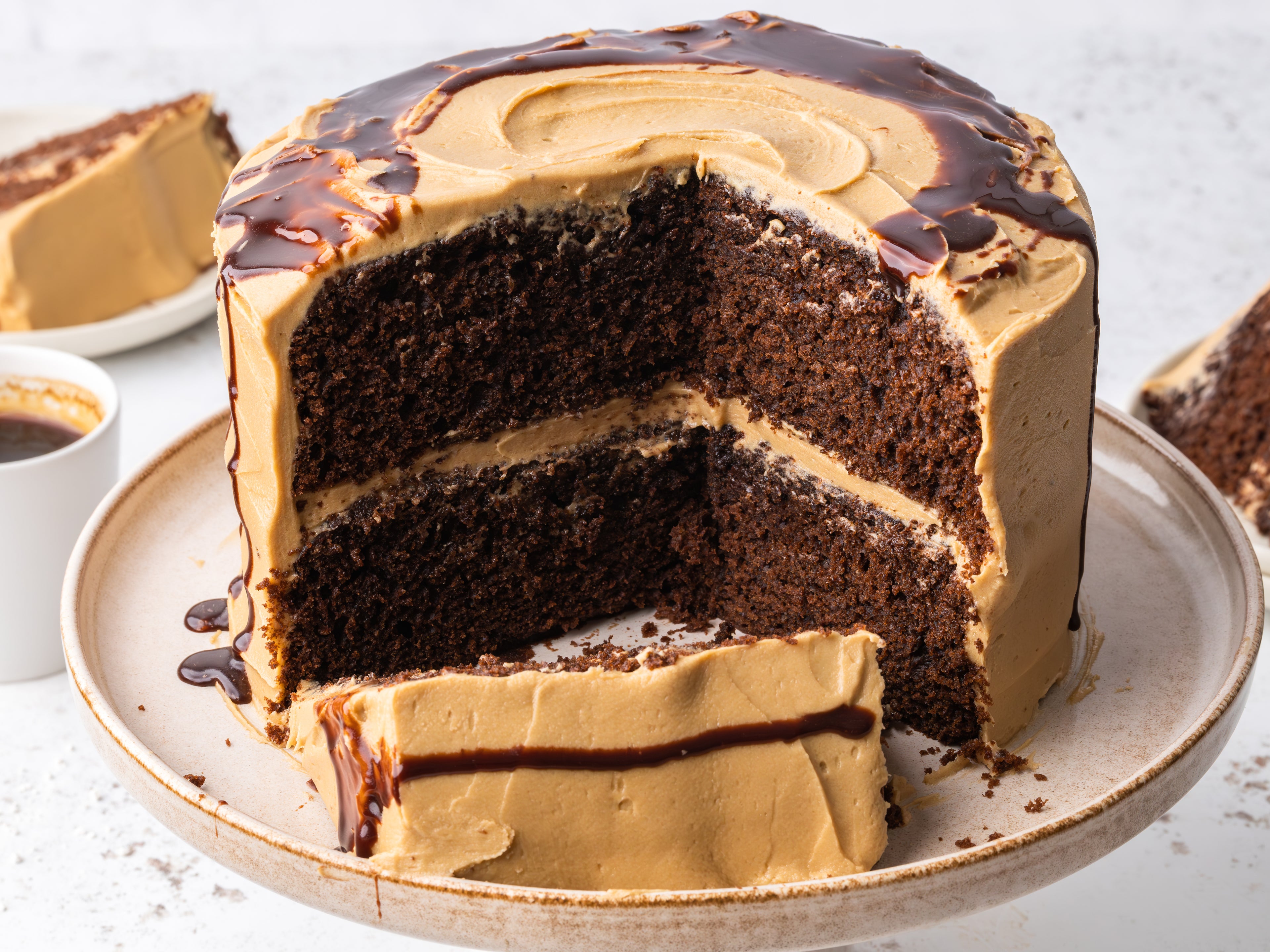 Chocolate espresso layer cake with a large slice removed and a slice laying down infront of the cake