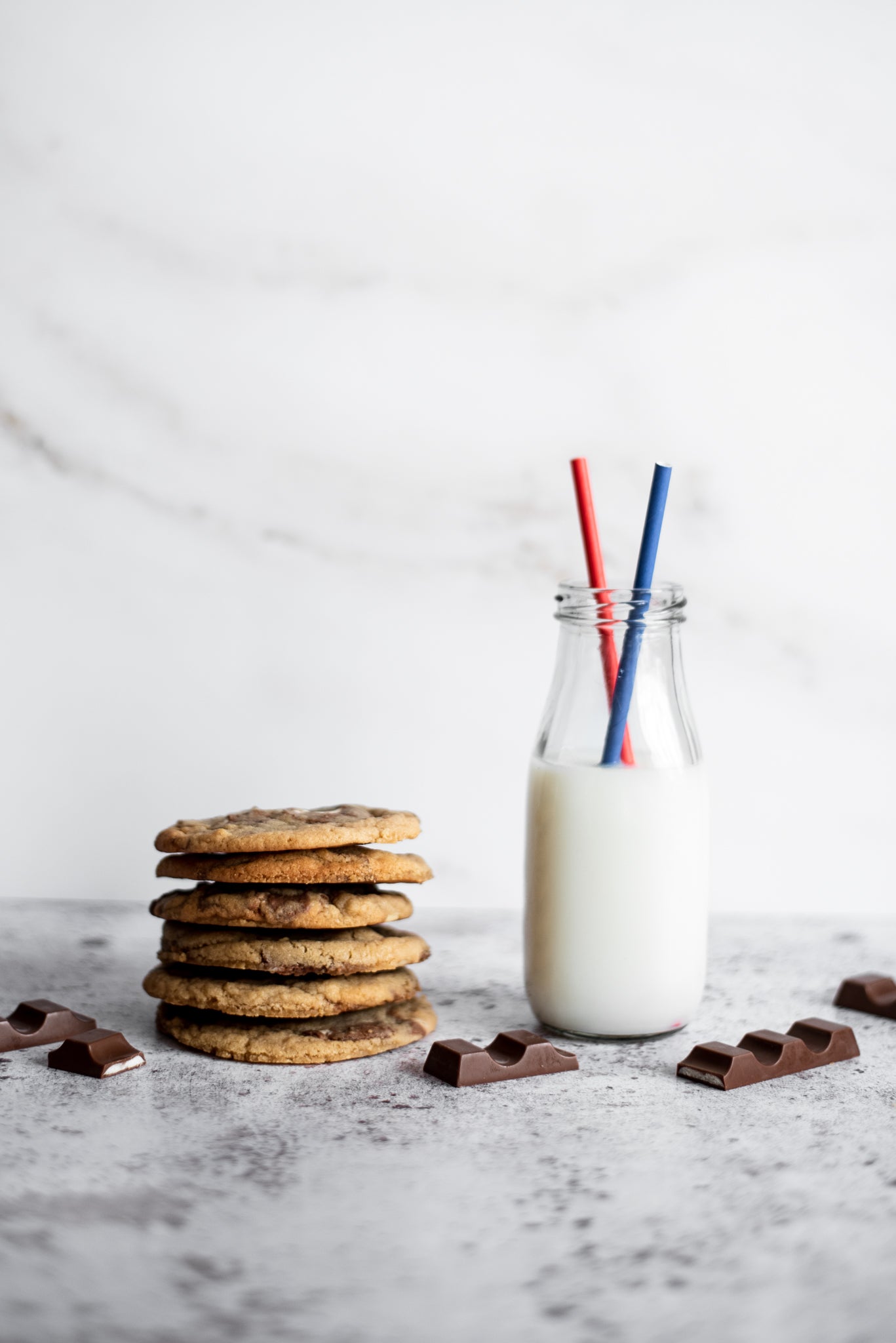 Six kinder copycat millies cookies in a neat pile next to a milk bottle with two straws