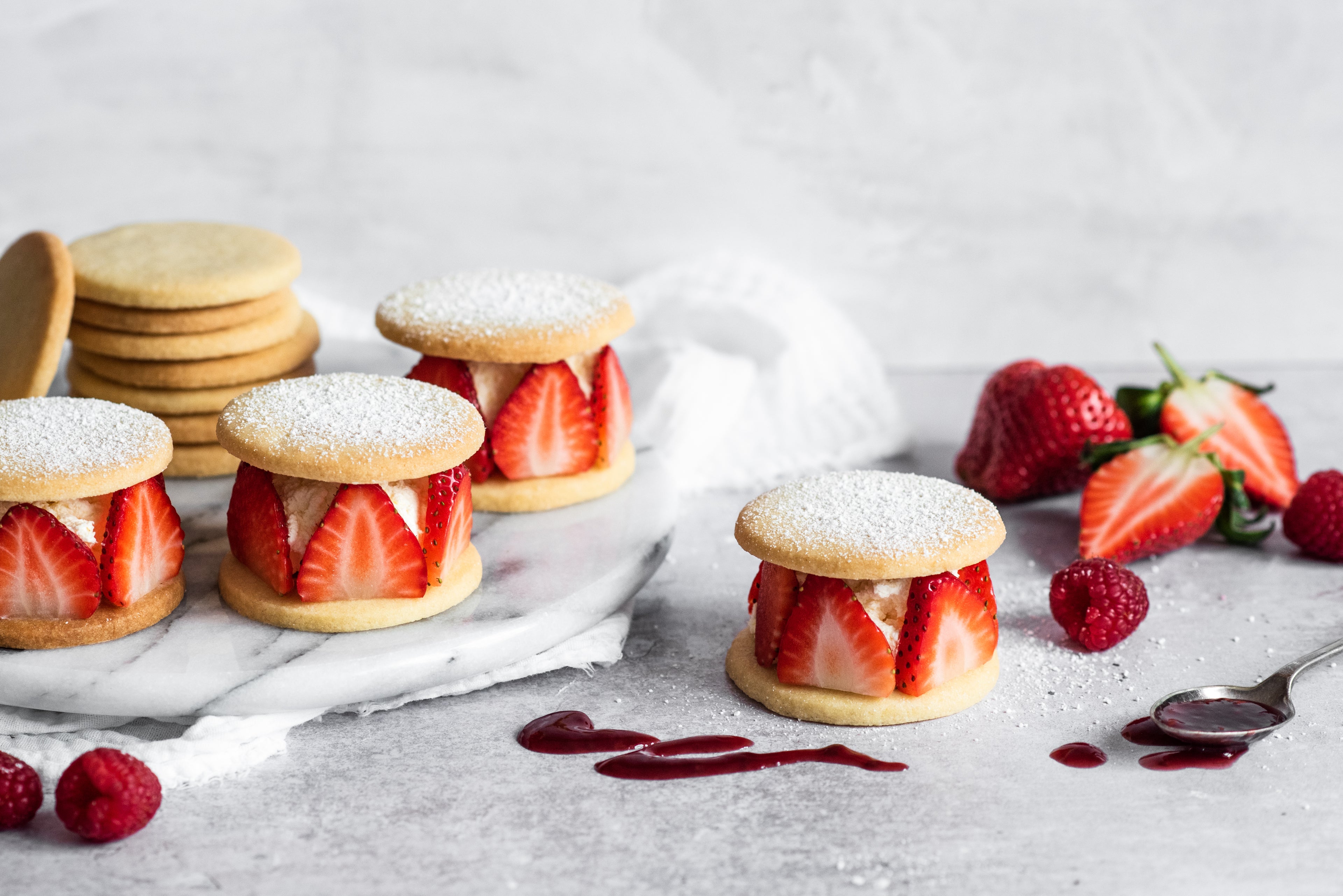 Shortbread rounds with sliced strawberries and cream sandwiched between