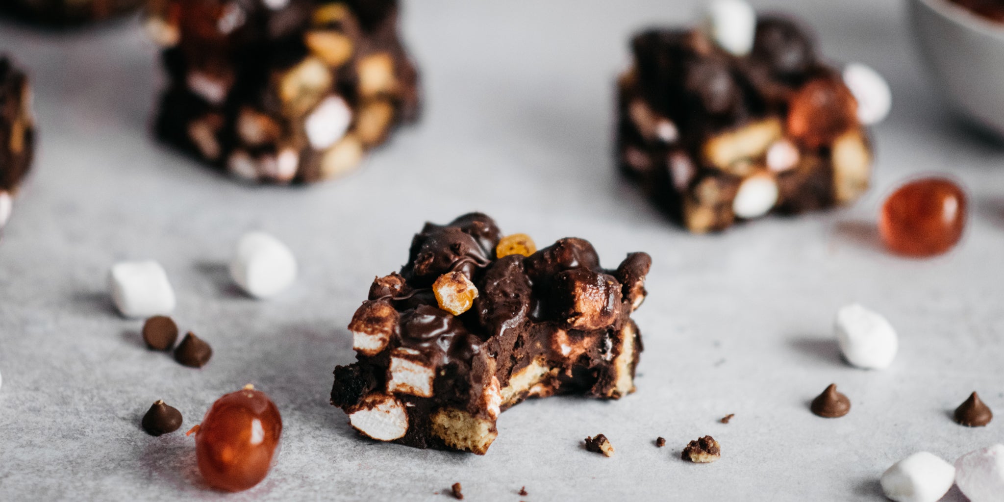 Close up of a slice of Vegan Rocky Road filled with cherries, marshmallows and plant based chocolate