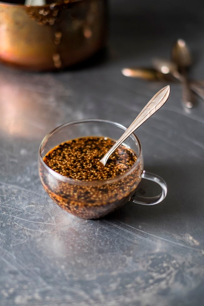 Small glass mug of billingtons sesame sauce with a spoon in it