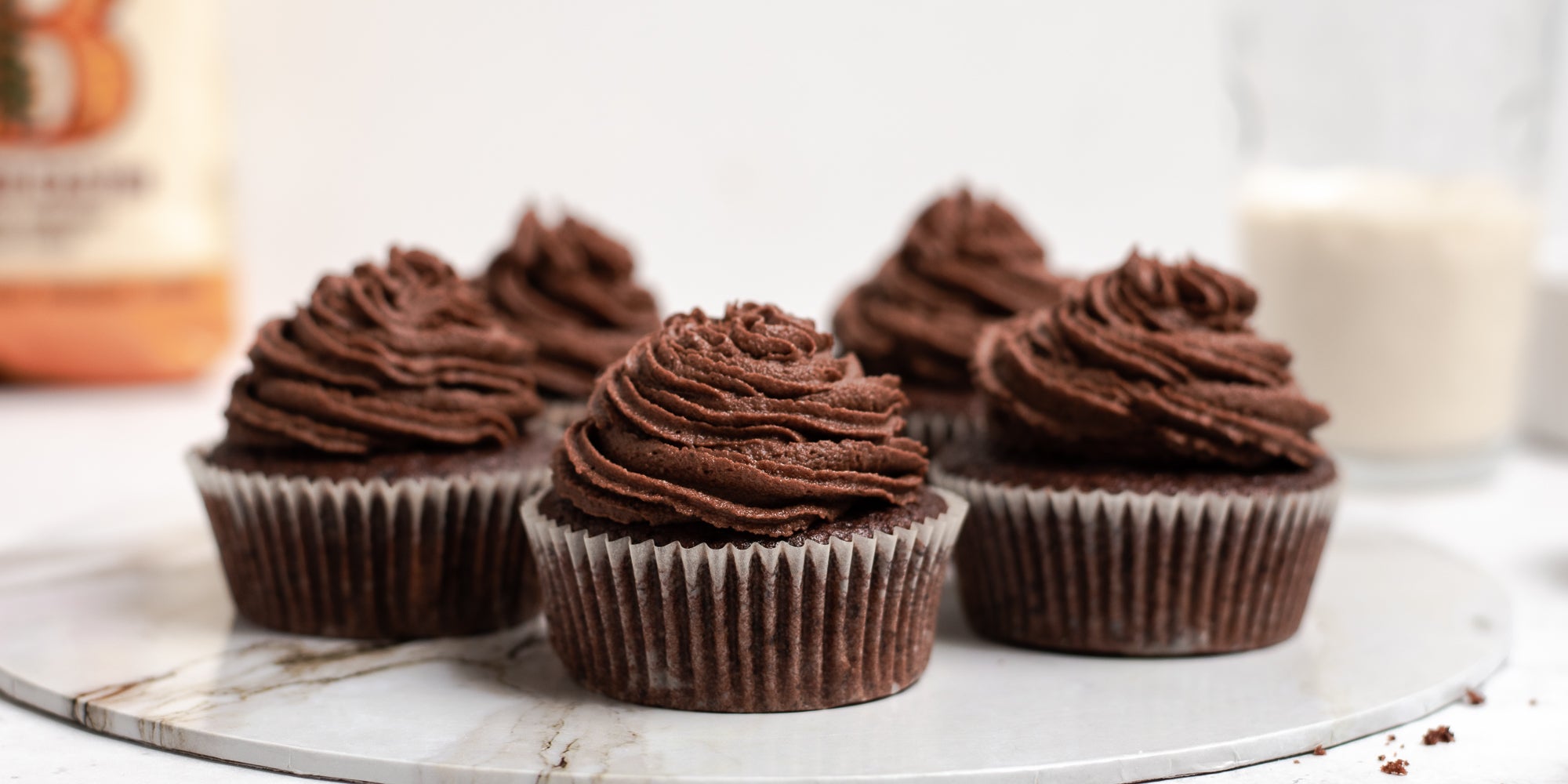 Close up of Vegan Chocolate Cupcakes piped with vegan chocolate buttercream, served on a marble tray