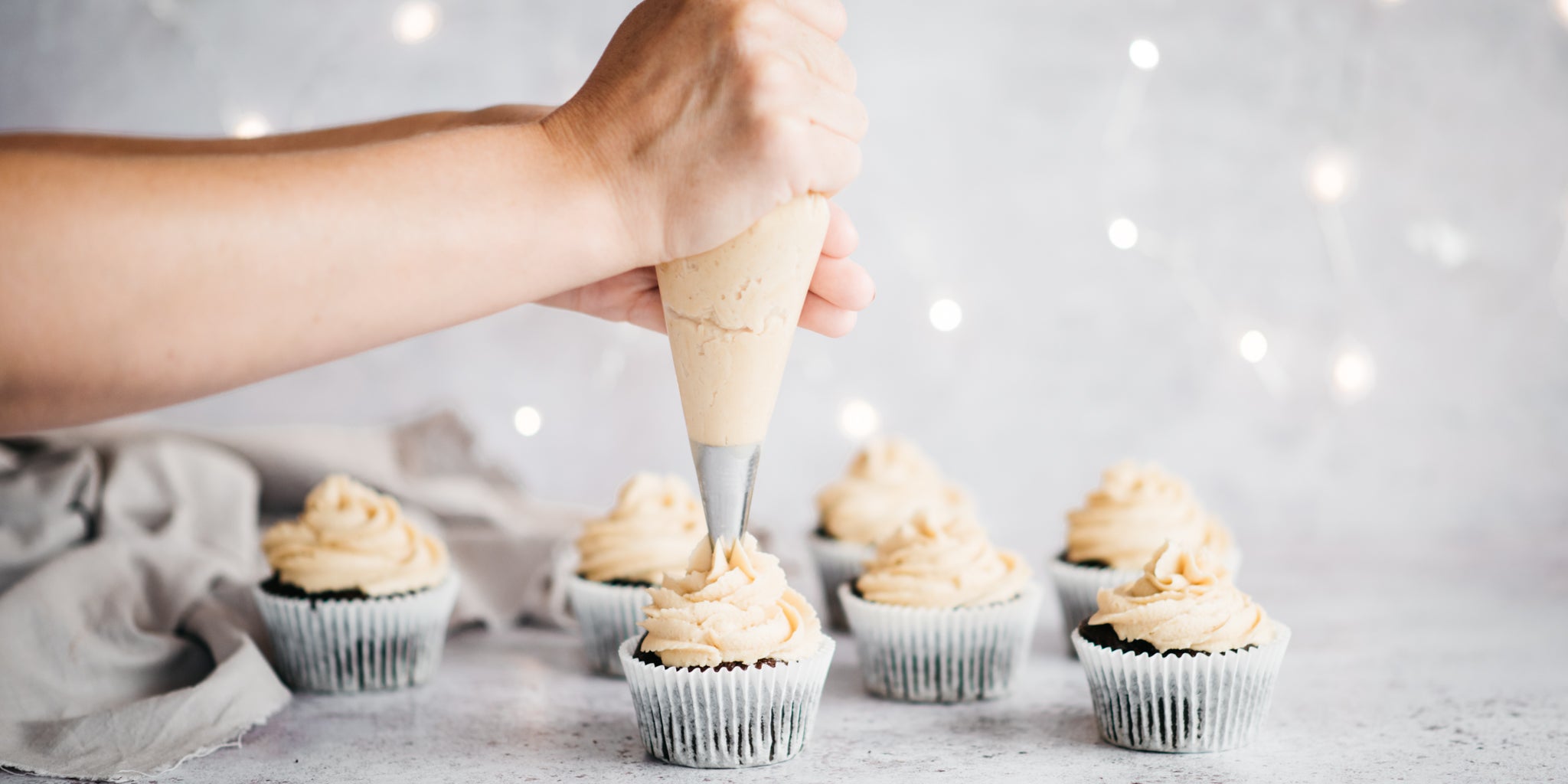 Hand piping buttercream on top of chocolate muffins