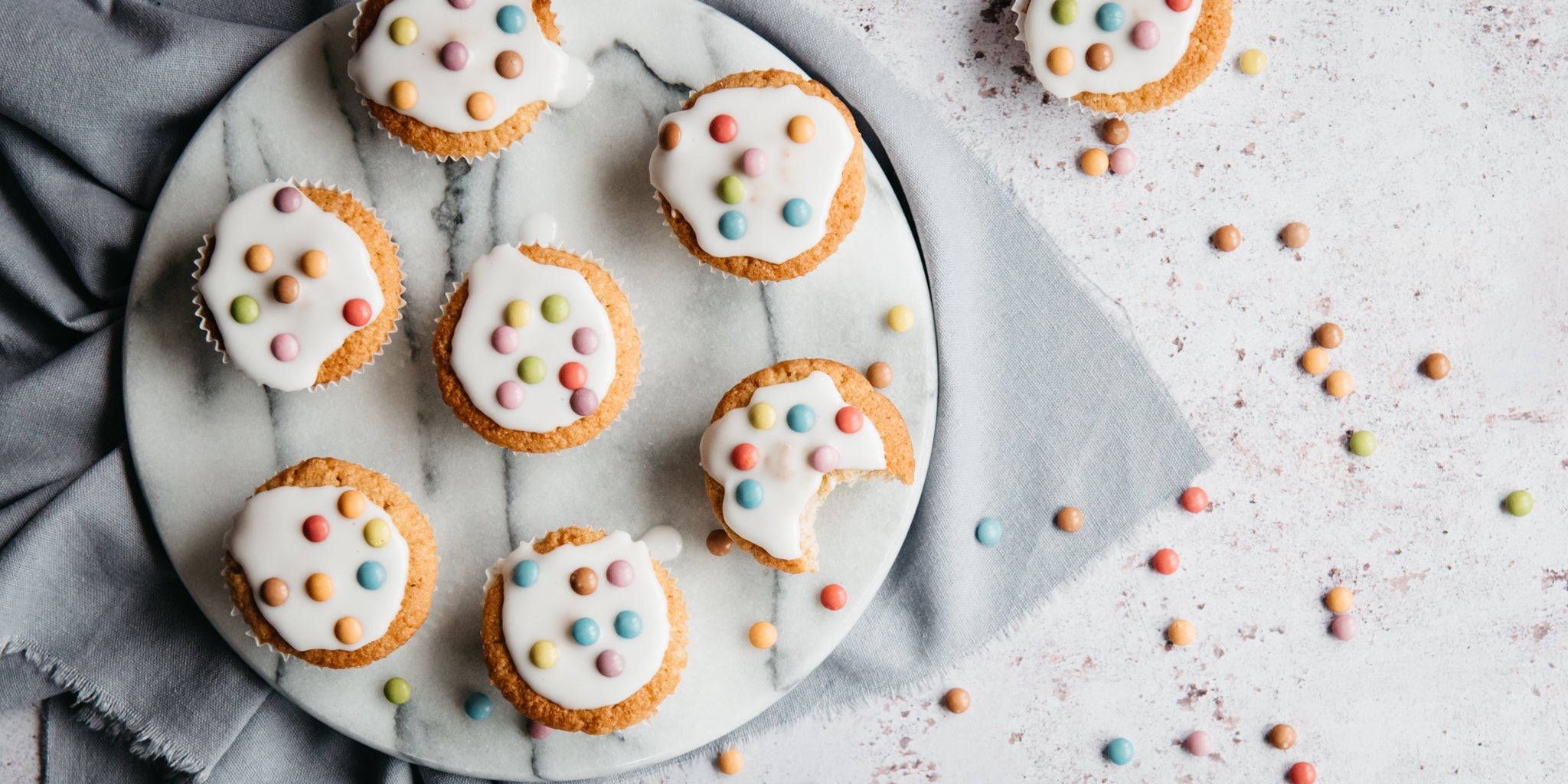 Top view of Wholemeal Fairy Cakes on a marble cake stand, with a bite taken out of a cupcake