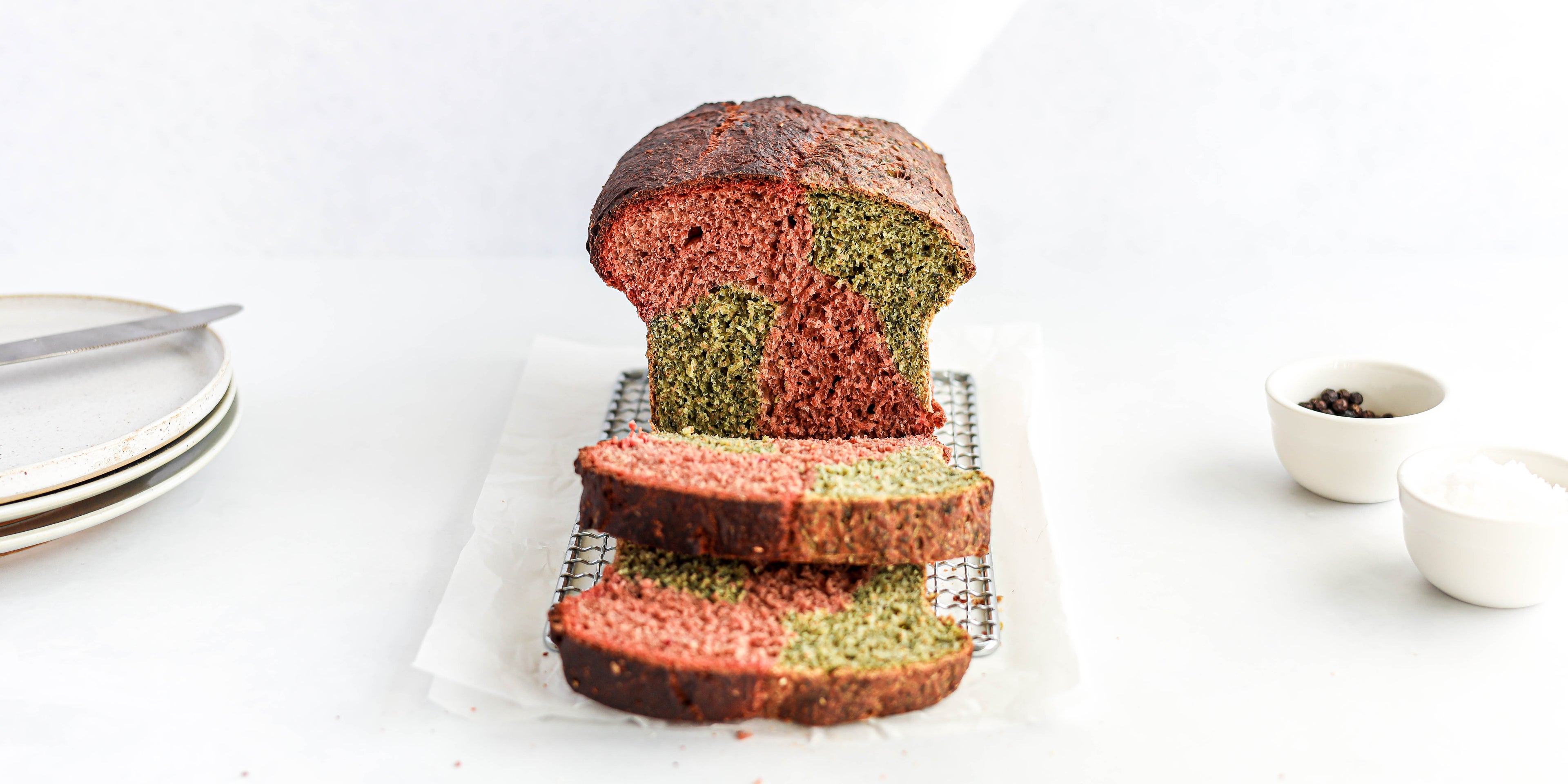 Marble Vegetable Bread close up, with two slices cut off the end, showing the pink and green insides of the vegetable loaf