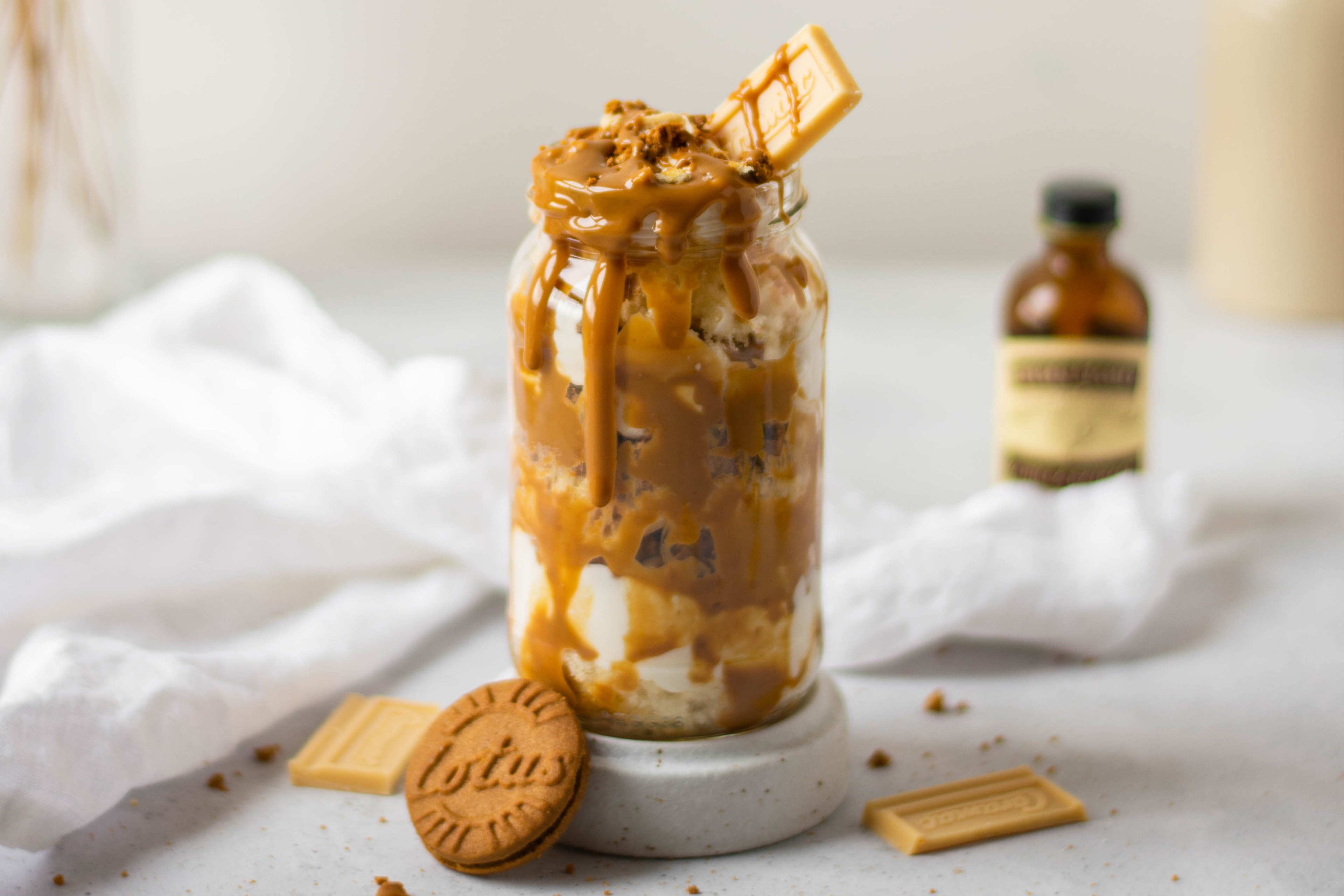 Close up of Biscoff & Caramac Cake Jar with a bottle of Nielsen-Massey Vanilla Extract in the background